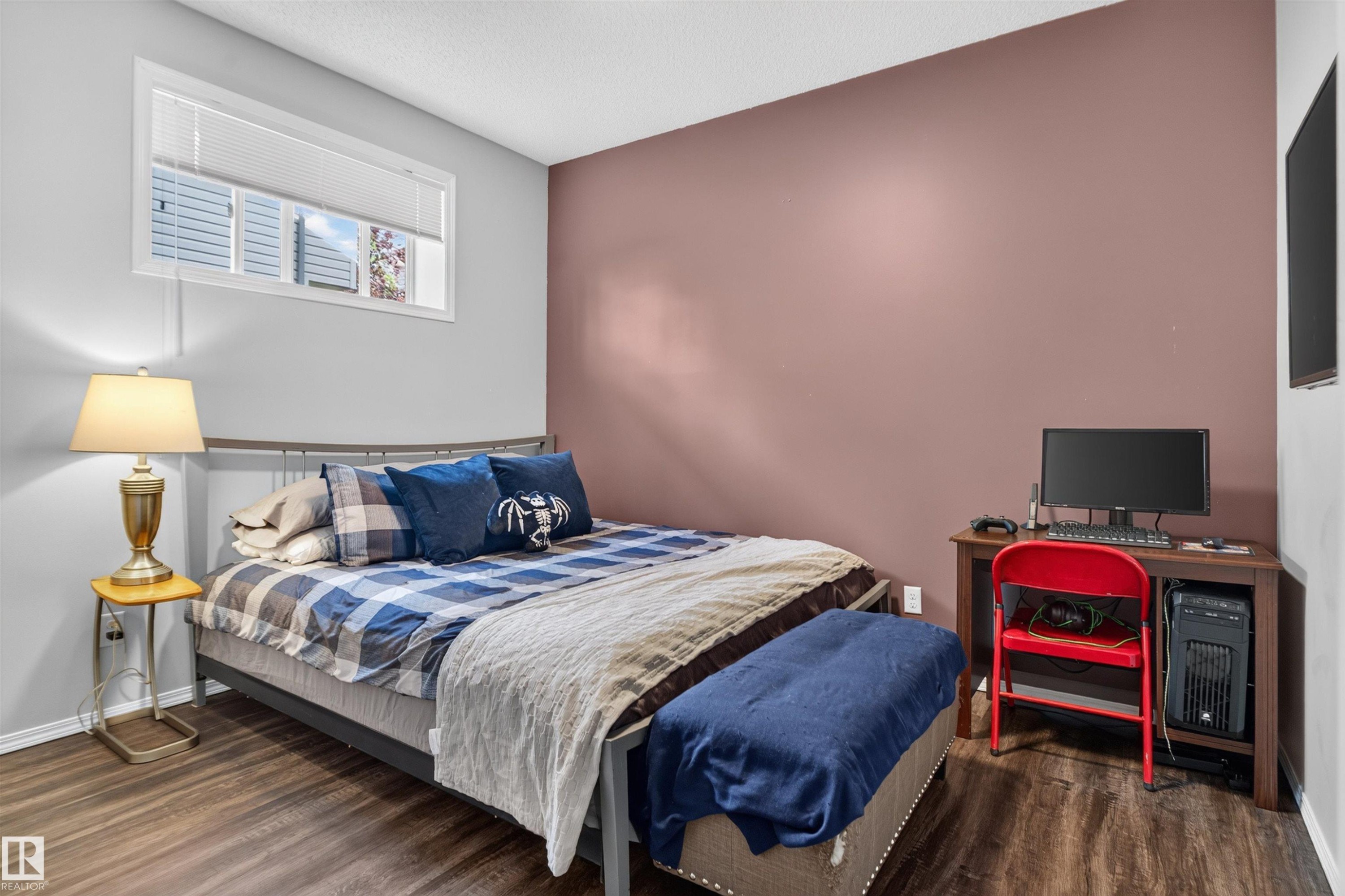 Wood-finish flooring, two-tone painted walls, and a window with blinds - #34 6520 2 Av Sw, Edmonton, AB - Indoor Photo Showing Bedroom