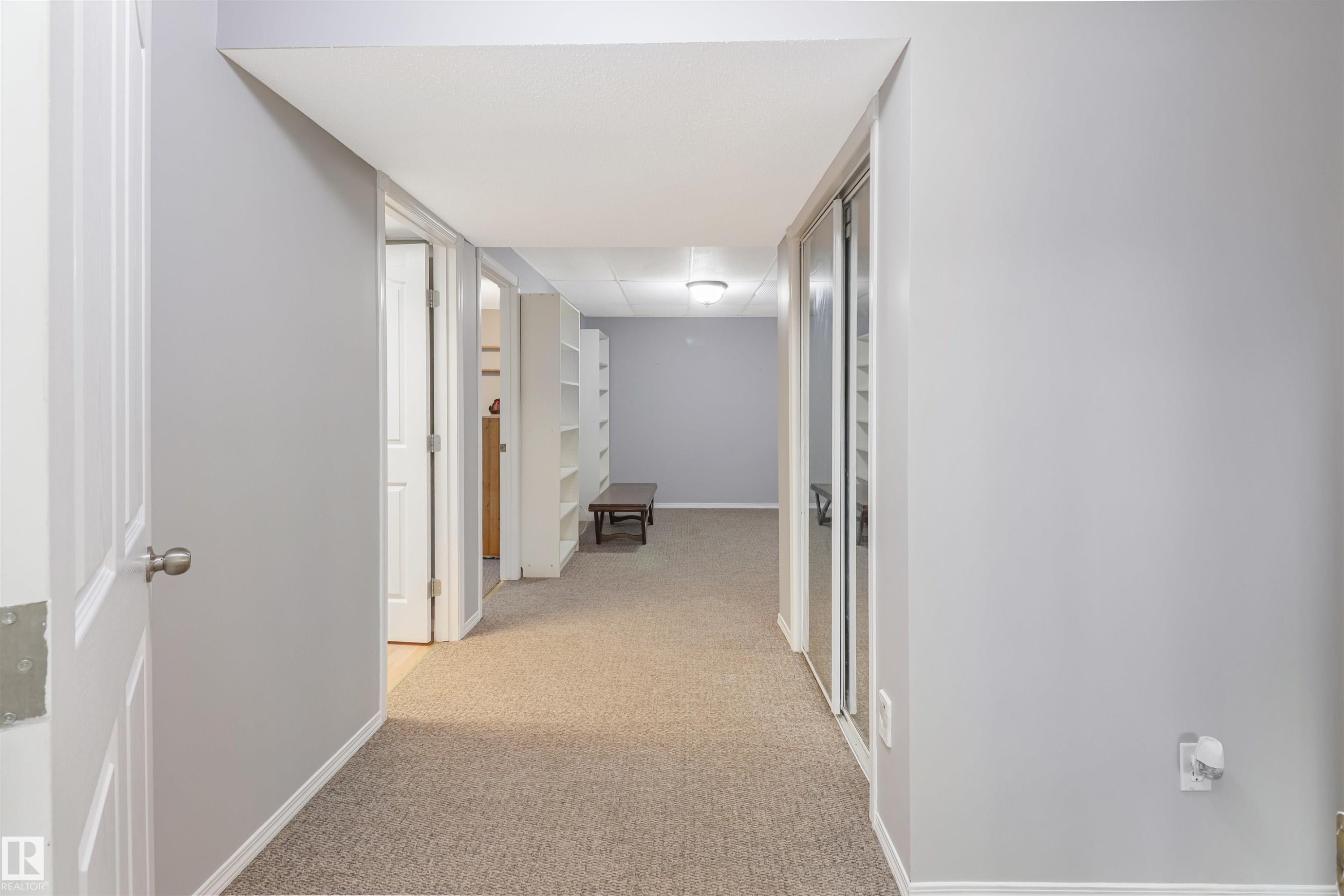 Bright hallway with neutral wall finishes, recessed ceiling lighting, and neutral-tone carpeting throughout - 1055 Jones Crescent Nw, Edmonton, AB - Indoor Photo Showing Other Room