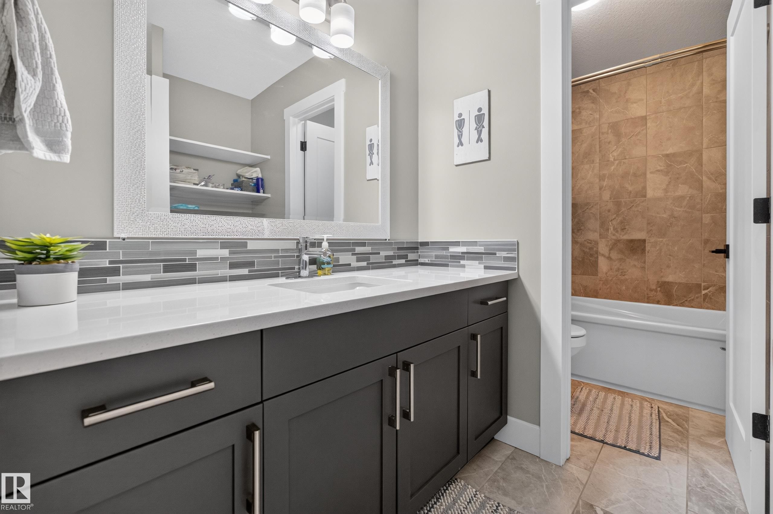 Dual vanity with a white countertop, gray shaker-style cabinetry, and mosaic tile backsplash - 1399 Graydon Hill Way Sw, Edmonton, AB