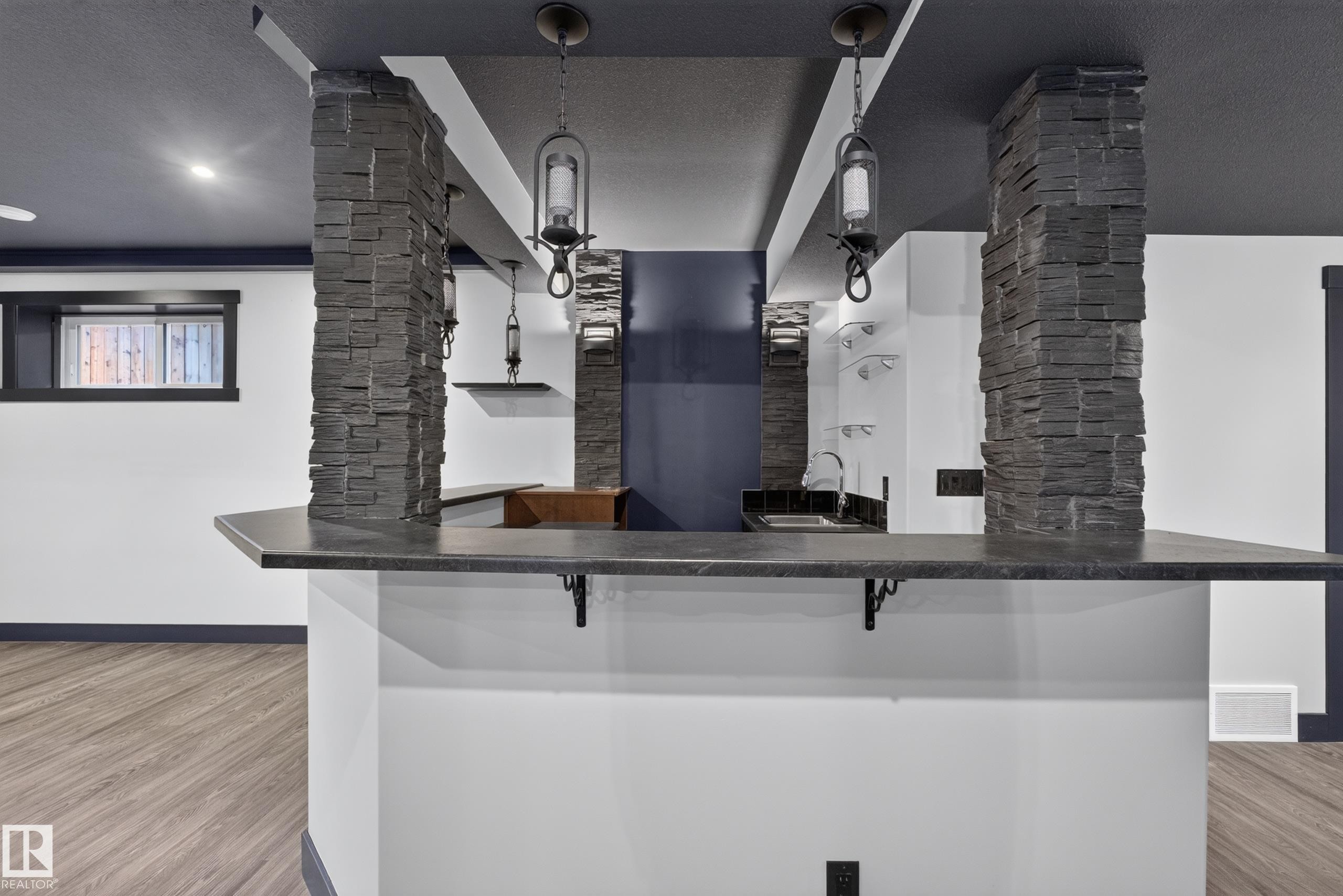 Built-in bar with dark countertop and sink - 1399 Graydon Hill Way Sw, Edmonton, AB