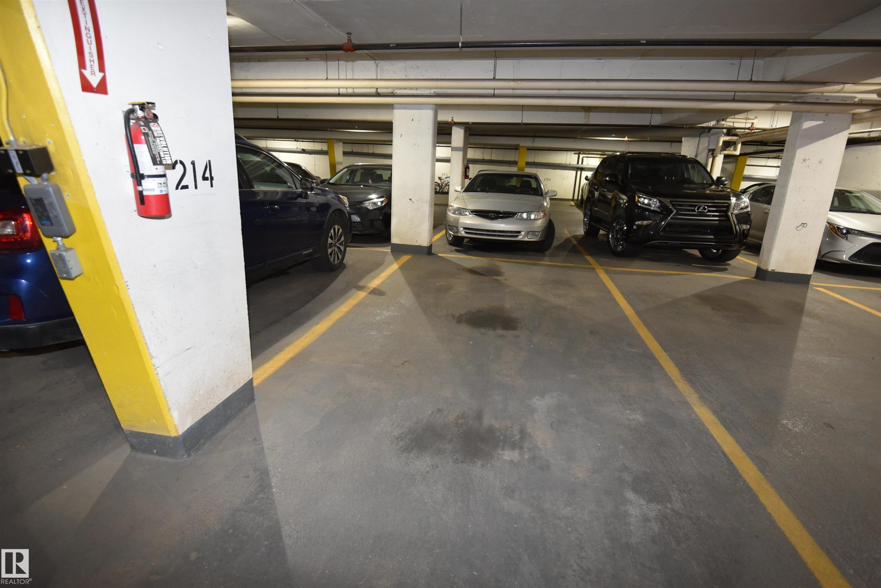 Underground parking space with designated yellow striping - #706 9741 110 St Nw, Edmonton, AB - Indoor Photo Showing Garage