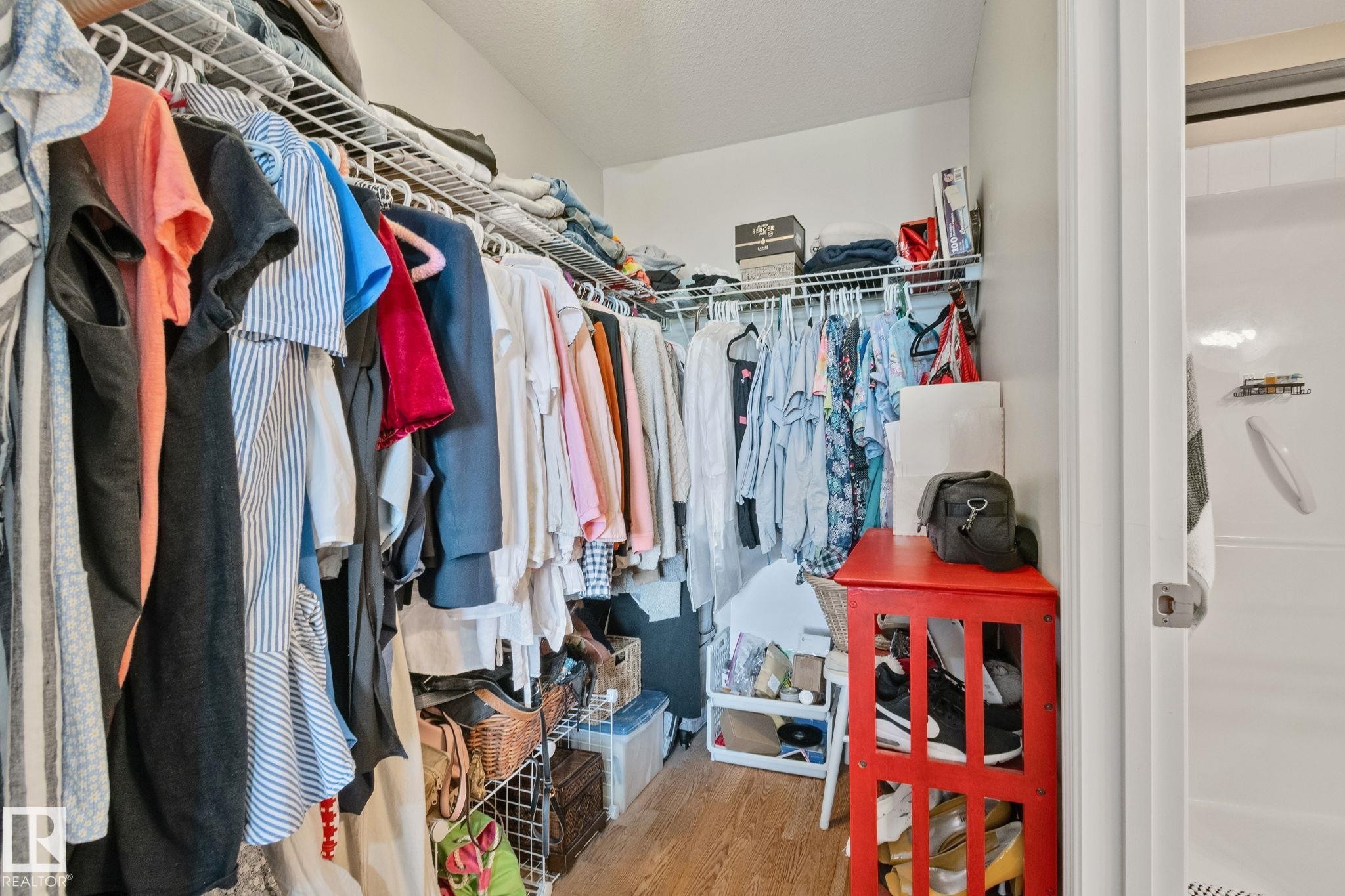 Wire shelving system, wood-finish flooring, and white walls - #407 4309 33 St, Stony Plain, AB - Indoor With Storage