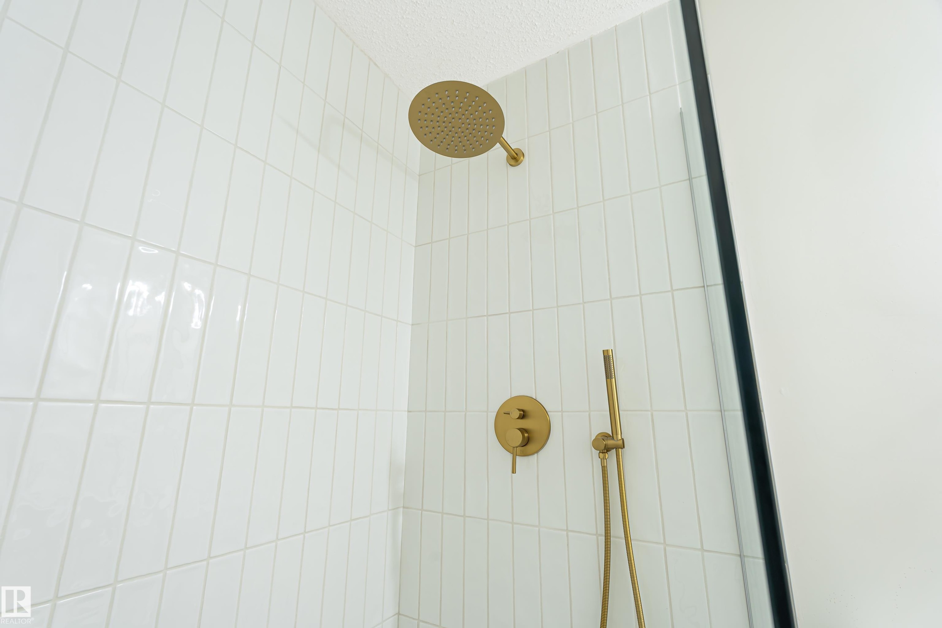 White subway tile shower enclosure with gold-finish fixtures - #21 9375 172 St Nw, Edmonton, AB - Indoor Photo Showing Bathroom
