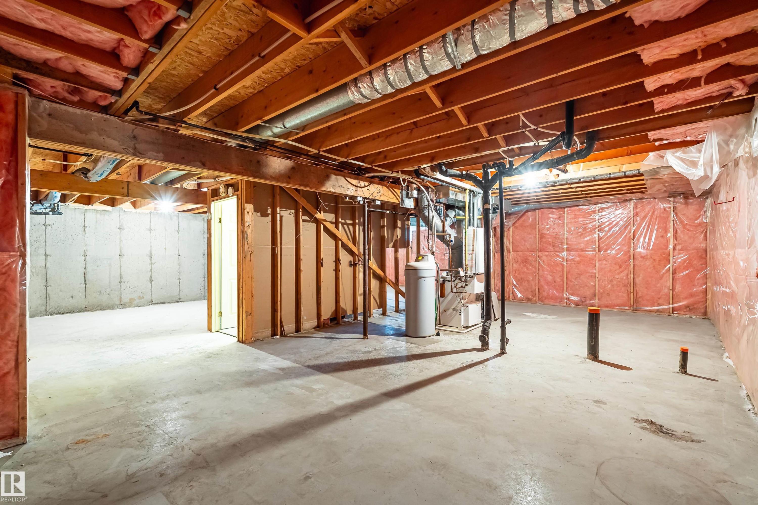 Unfinished basement with concrete flooring, exposed wood ceiling joists, and visible insulation - #21 9375 172 St Nw, Edmonton, AB - Indoor Photo Showing Basement