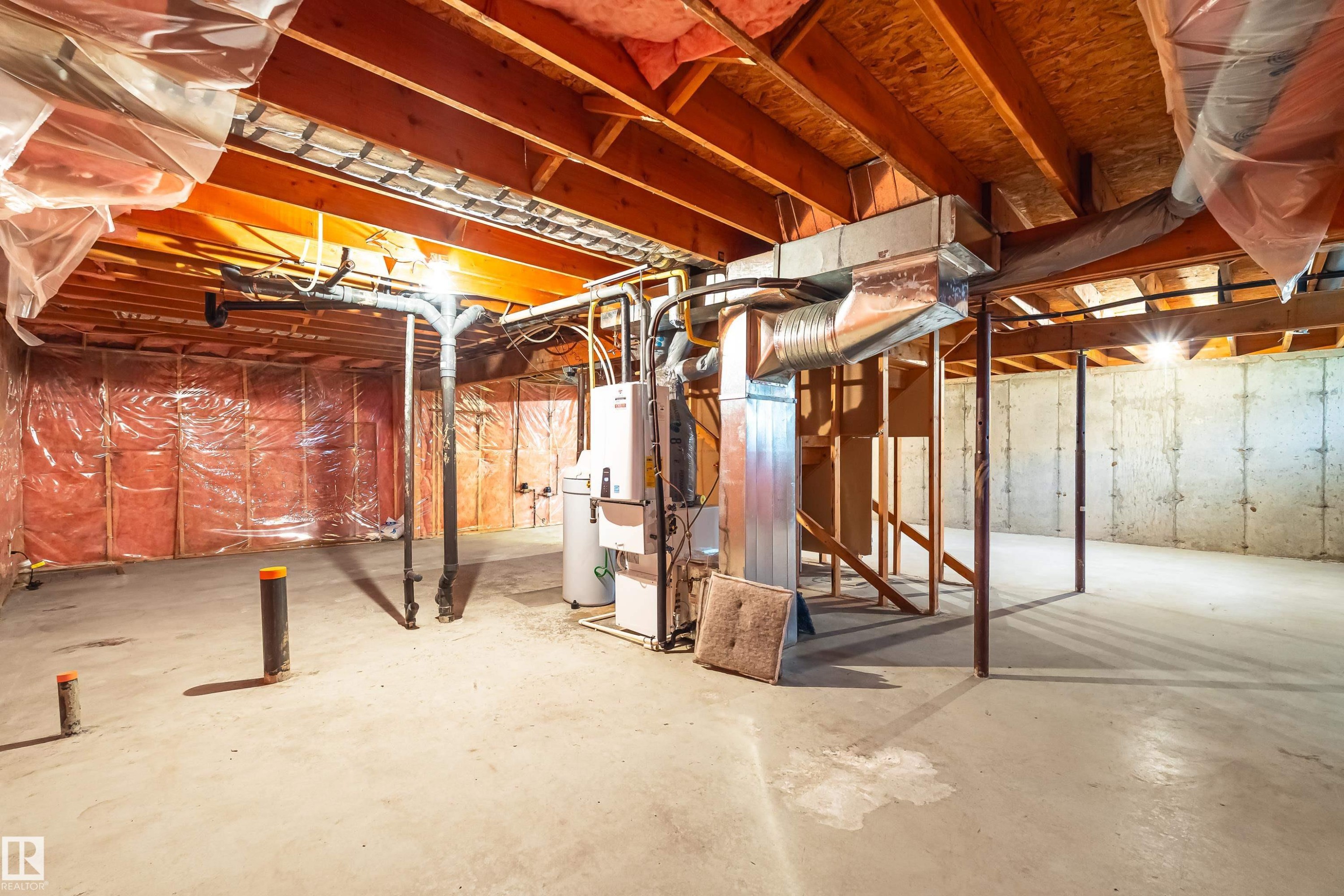 Unfinished basement featuring exposed wood joists, concrete foundation walls, and visible insulation - #21 9375 172 St Nw, Edmonton, AB - Indoor Photo Showing Basement