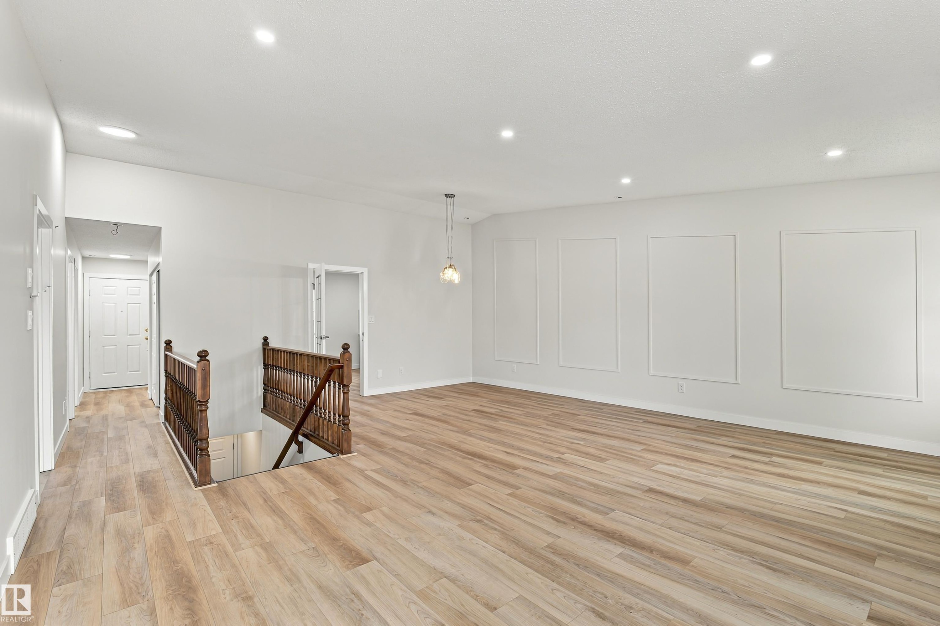 Spacious interior featuring wood-finish flooring, recessed lighting, and decorative wall paneling - #21 9375 172 St Nw, Edmonton, AB - Indoor Photo Showing Other Room