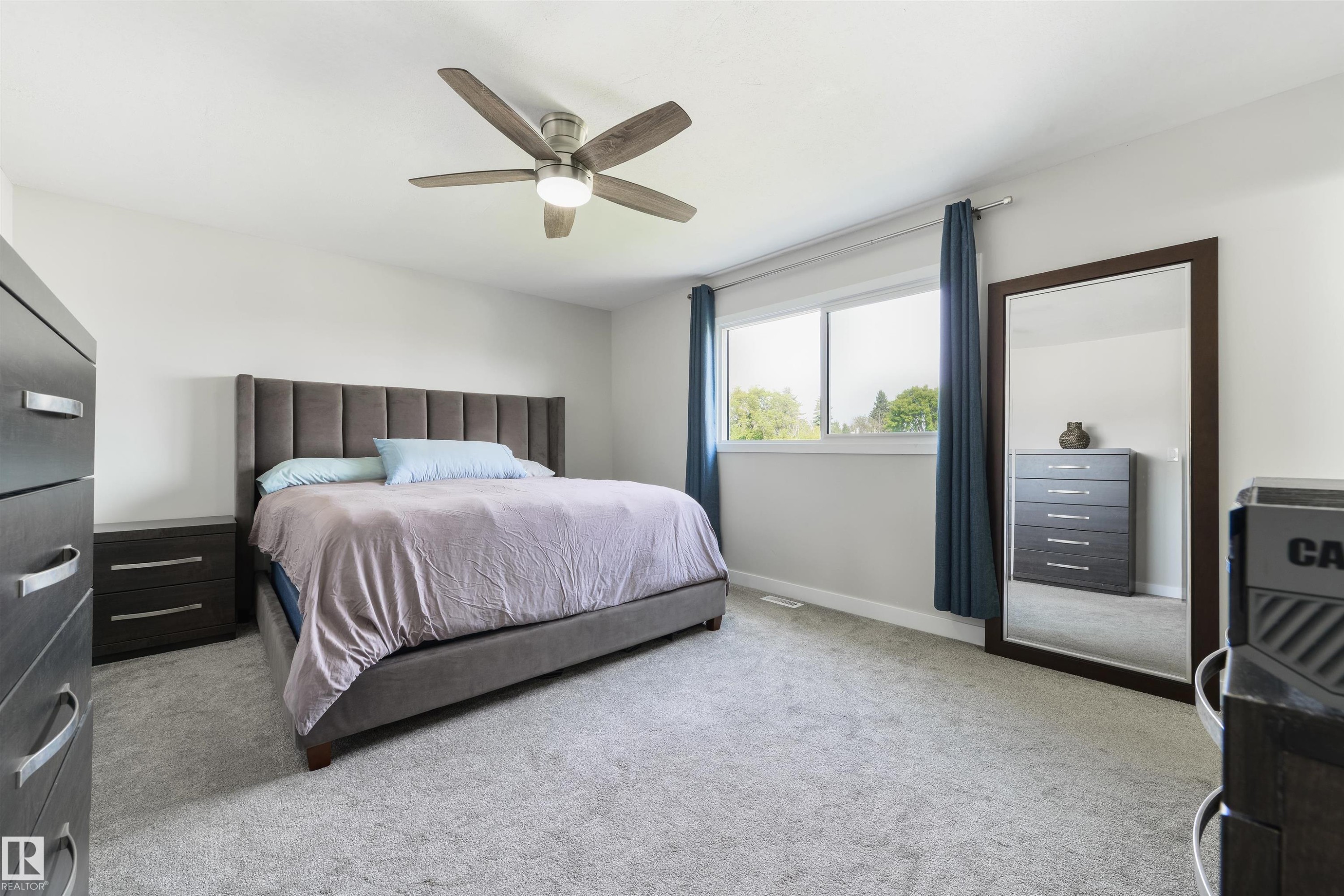 Recessed lighting, ceiling fan with integrated lighting, large window, and light gray carpeting - 4614 53 Ave, Calmar, AB - Indoor Photo Showing Bedroom