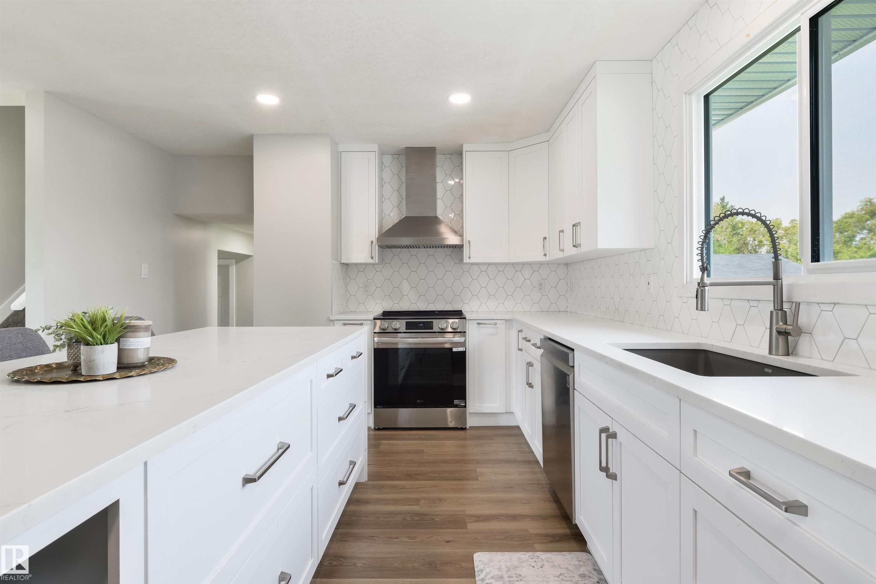 White cabinetry and island with light-toned countertops - 4614 53 Ave, Calmar, AB - Indoor Photo Showing Kitchen With Upgraded Kitchen