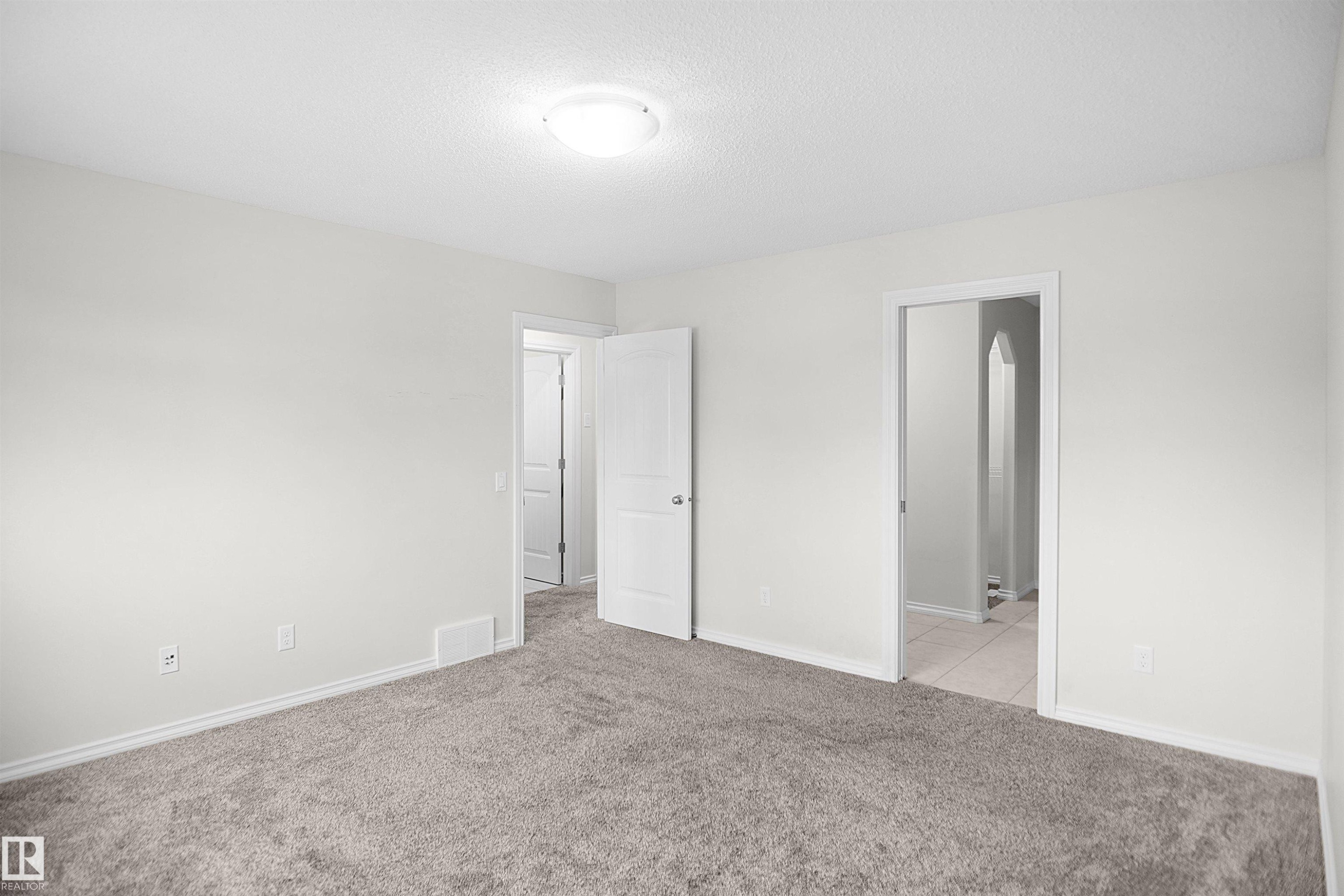 Neutral wall color, carpeted flooring, overhead lighting, white trim, and white interior doors - 8432 18 Avenue Sw, Edmonton, AB - Indoor Photo Showing Other Room