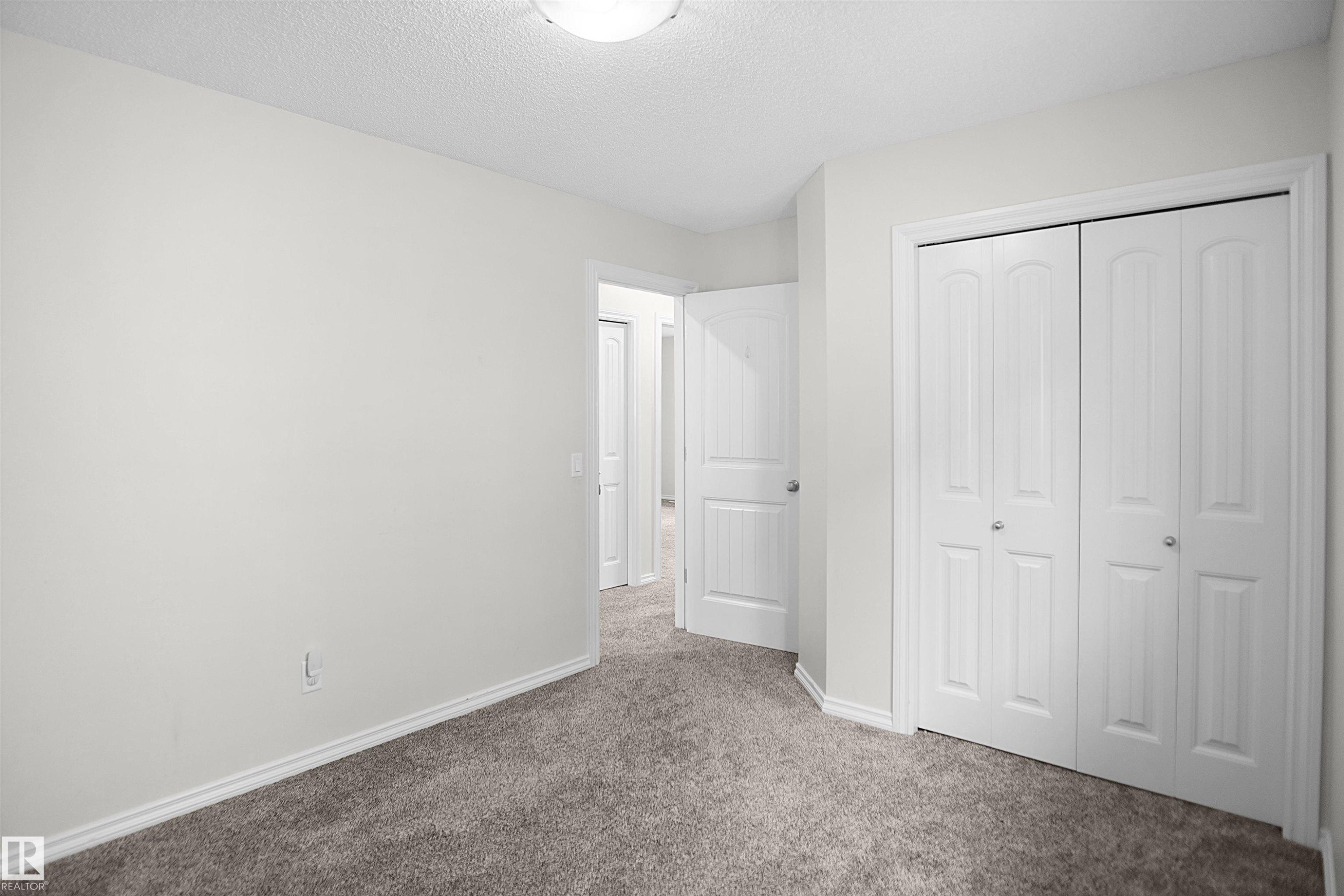 Wall-to-wall carpeting, bi-fold closet doors, and interior paneled doors with chrome hardware - 8432 18 Avenue Sw, Edmonton, AB - Indoor