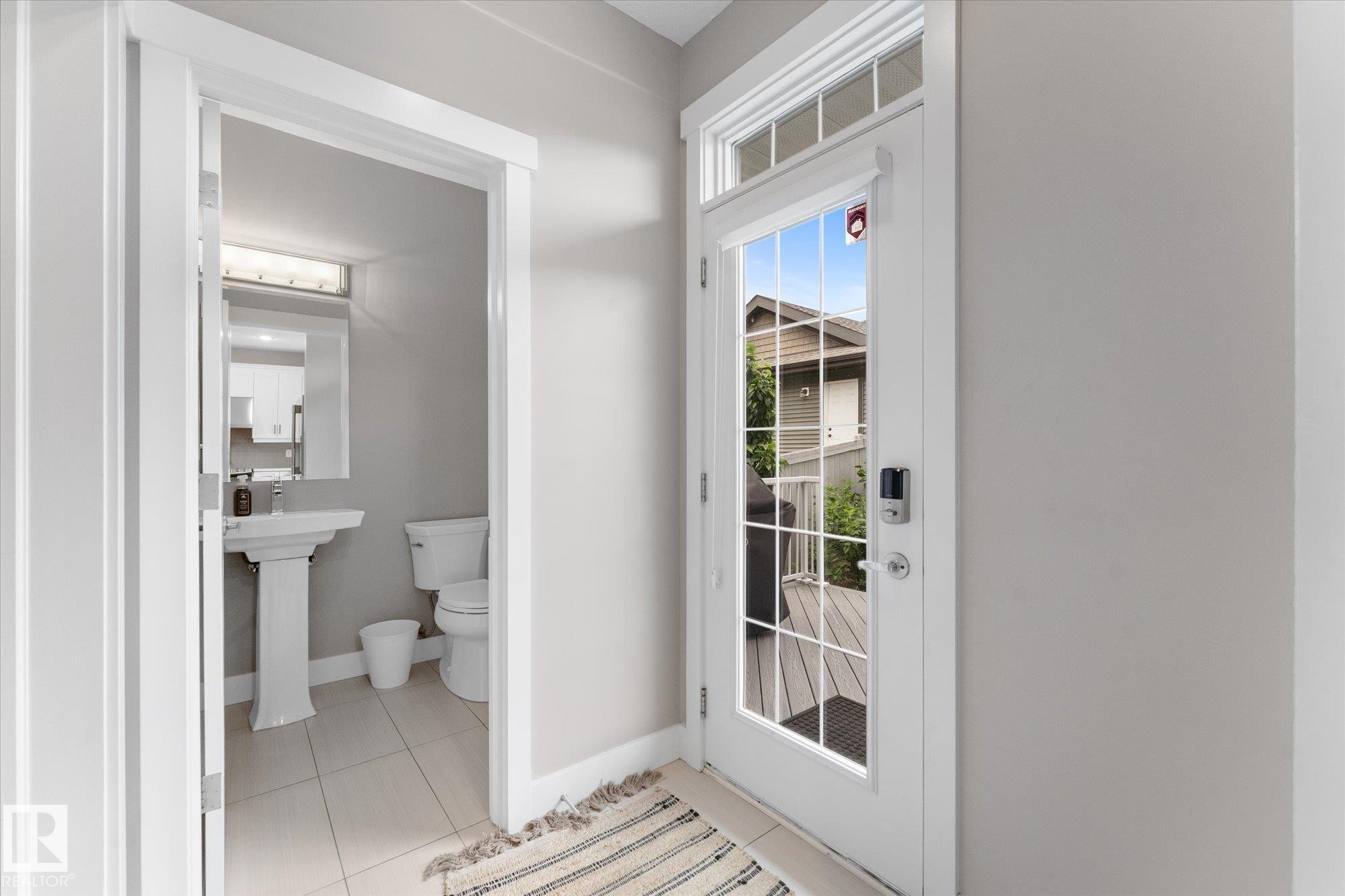 Entry door with transom window, glass panels, and smart lock system - 5616 Juchli Avenue Nw, Edmonton, AB - Indoor Photo Showing Bathroom