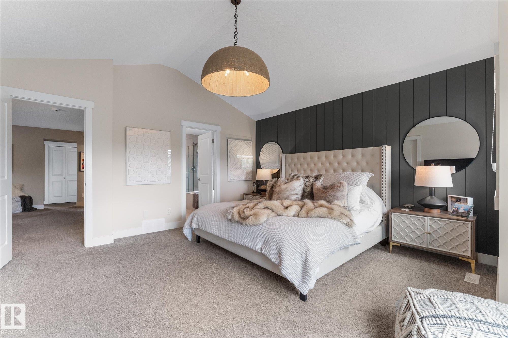 Spacious primary bedroom featuring a tufted upholstered headboard, soft white bedding, and carpeted flooring - 5616 Juchli Avenue Nw, Edmonton, AB - Indoor Photo Showing Bedroom