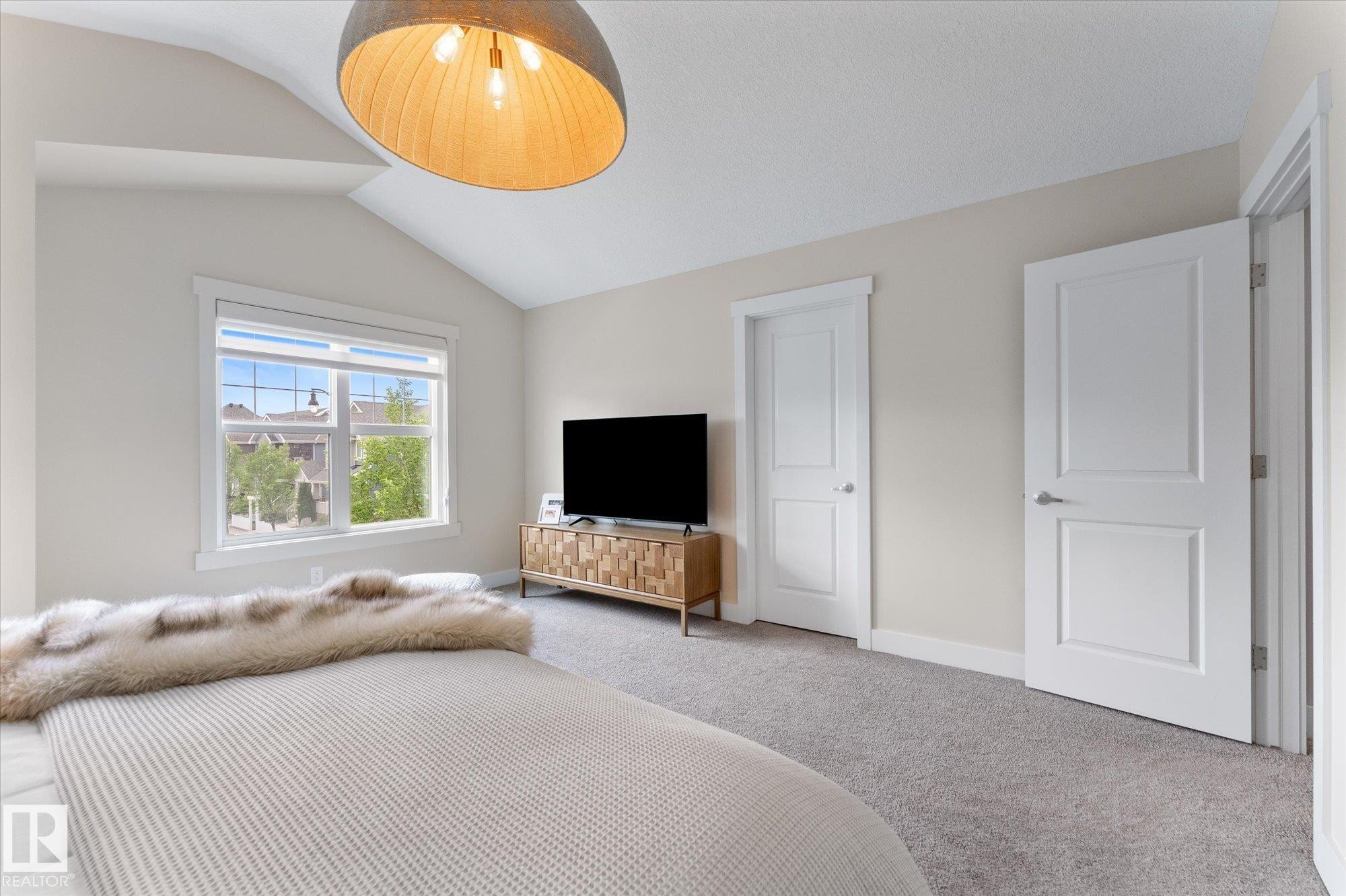 Spacious primary bedroom suite featuring neutral wall finishes, wall-to-wall carpeting, and abundant natural light from a large window - 5616 Juchli Avenue Nw, Edmonton, AB - Indoor Photo Showing Bedroom