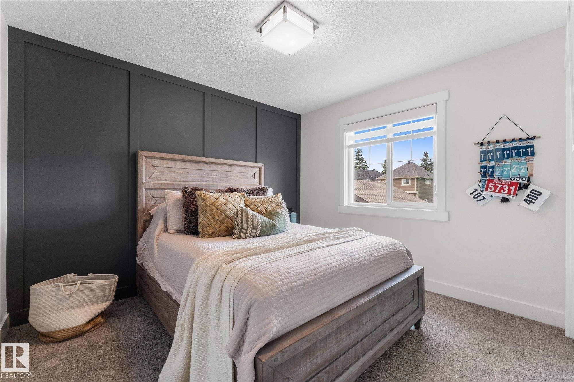 Accent wall with paneling, window with white trim, wall-to-wall carpeting, and overhead light fixture - 5616 Juchli Avenue Nw, Edmonton, AB - Indoor Photo Showing Bedroom