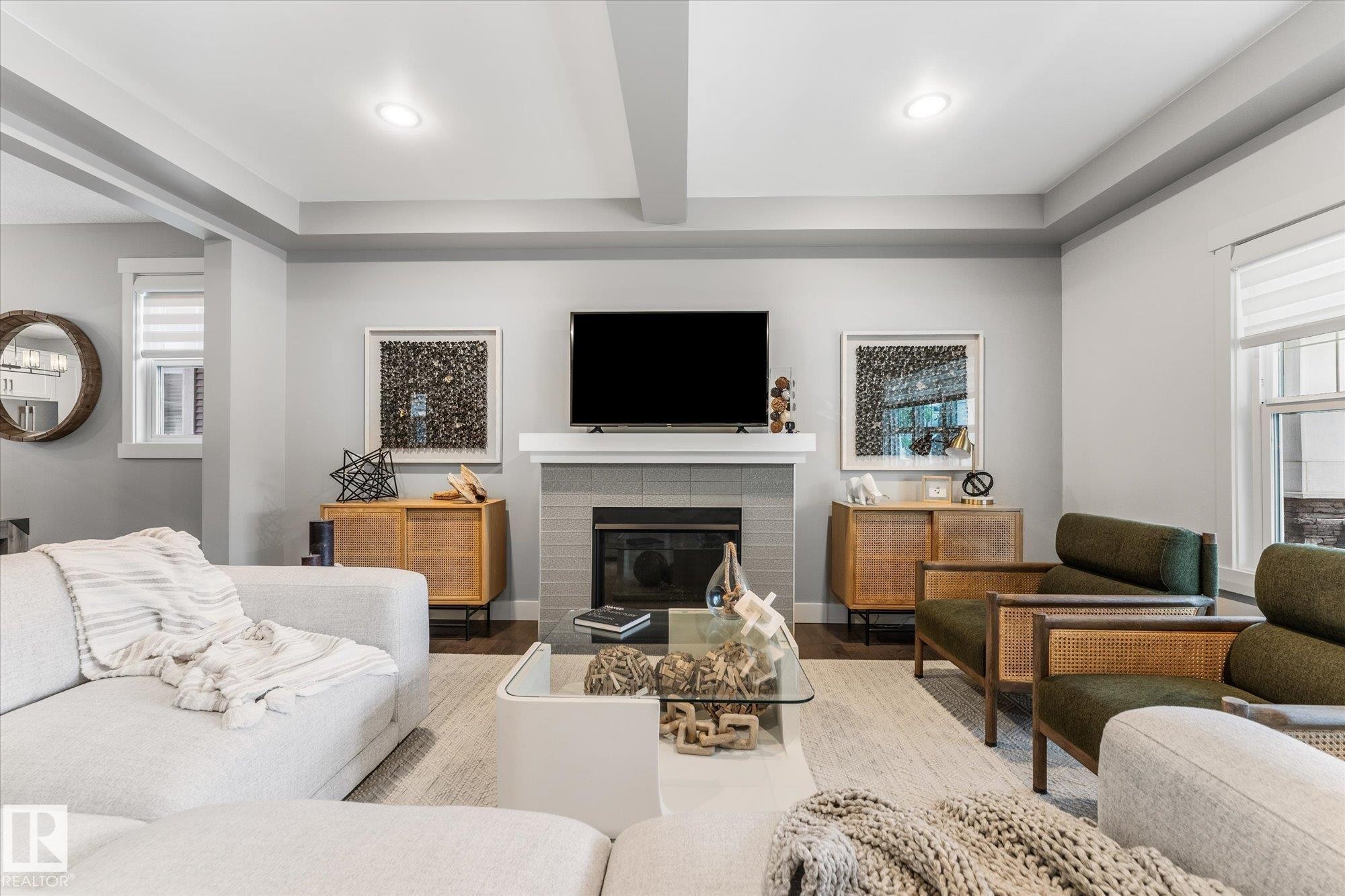 Recessed lighting, tray ceiling, tiled fireplace with mantel, and wood-finish flooring - 5616 Juchli Avenue Nw, Edmonton, AB - Indoor Photo Showing Living Room With Fireplace