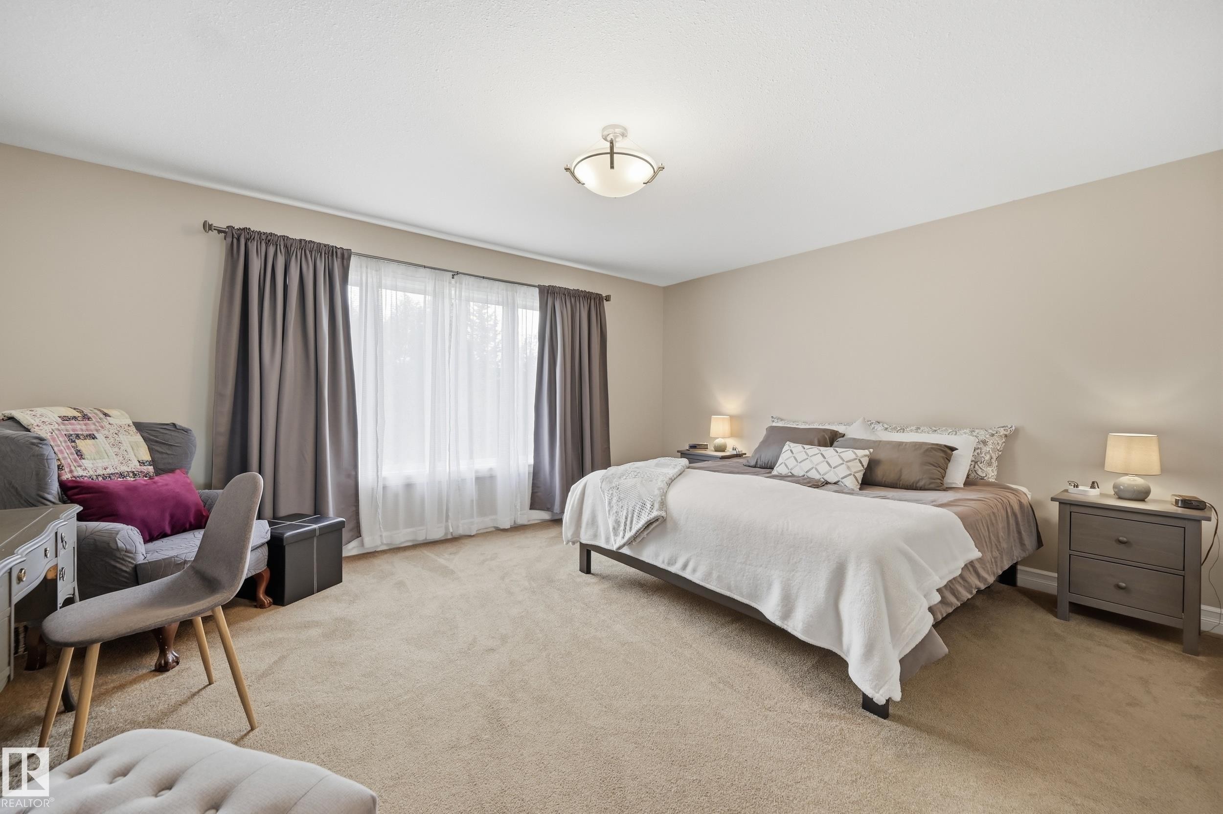 Neutral wall color, wall-to-wall carpeting, window with drapery, and a ceiling-mounted light fixture - 2416 Warry Place Sw, Edmonton, AB - Indoor Photo Showing Bedroom
