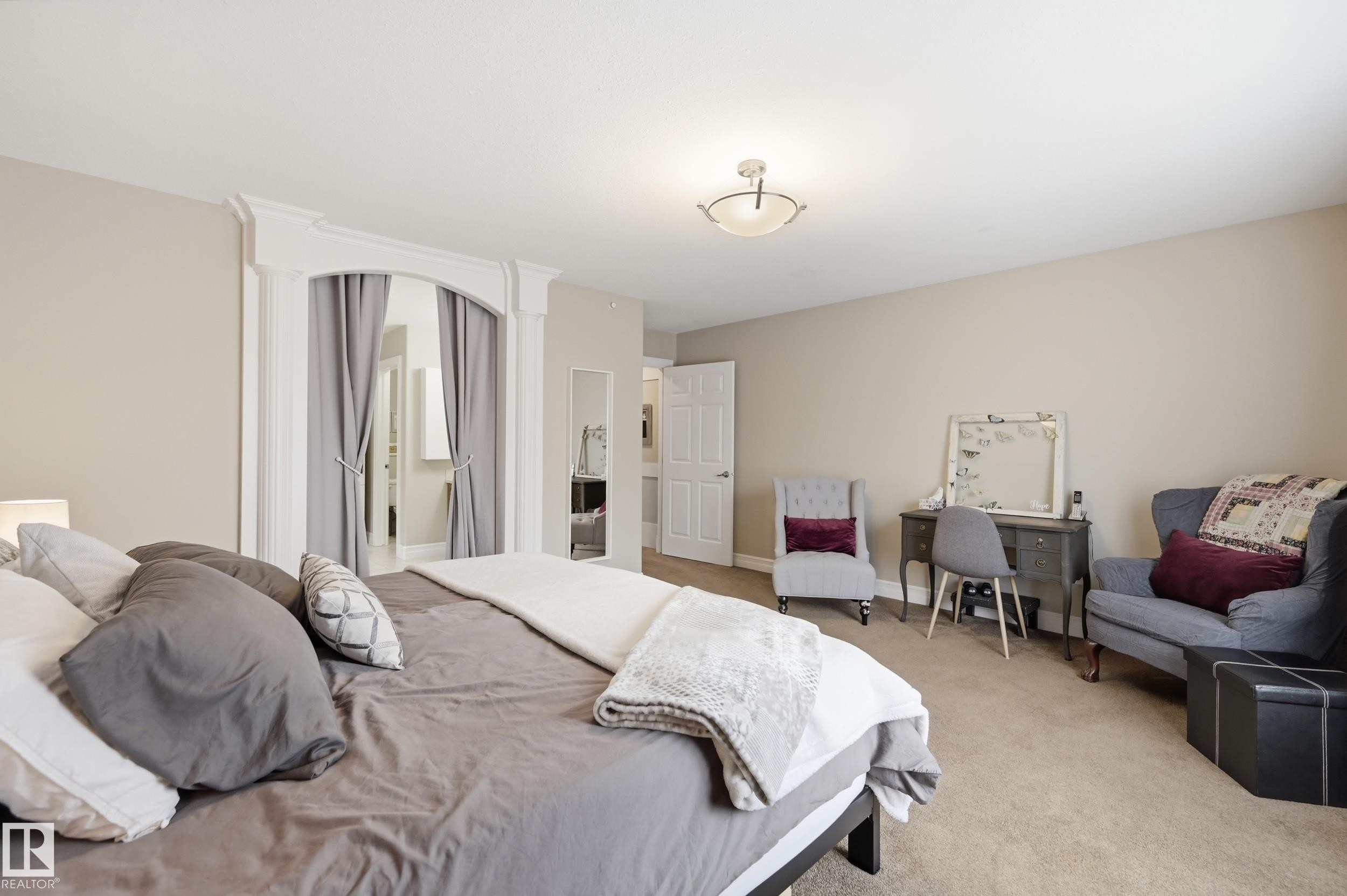 Recessed ceiling lighting, neutral wall paint, arched doorway with decorative trim, carpet flooring, and a flush mount ceiling fixture - 2416 Warry Place Sw, Edmonton, AB - Indoor Photo Showing Bedroom