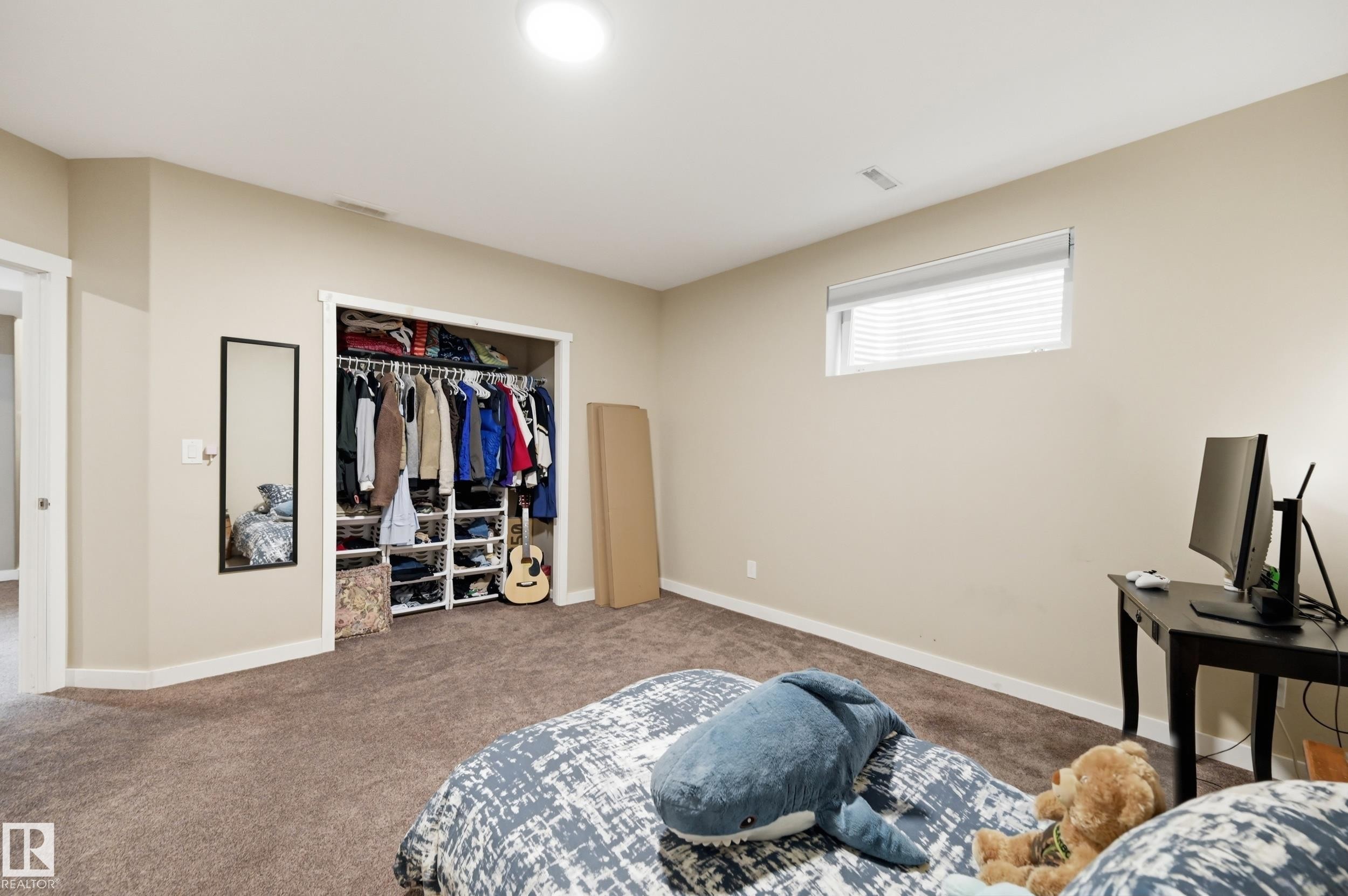 Recessed ceiling lighting, a window with horizontal blinds, and a built-in closet system with shelving and hanging rods - 2416 Warry Place Sw, Edmonton, AB - Indoor