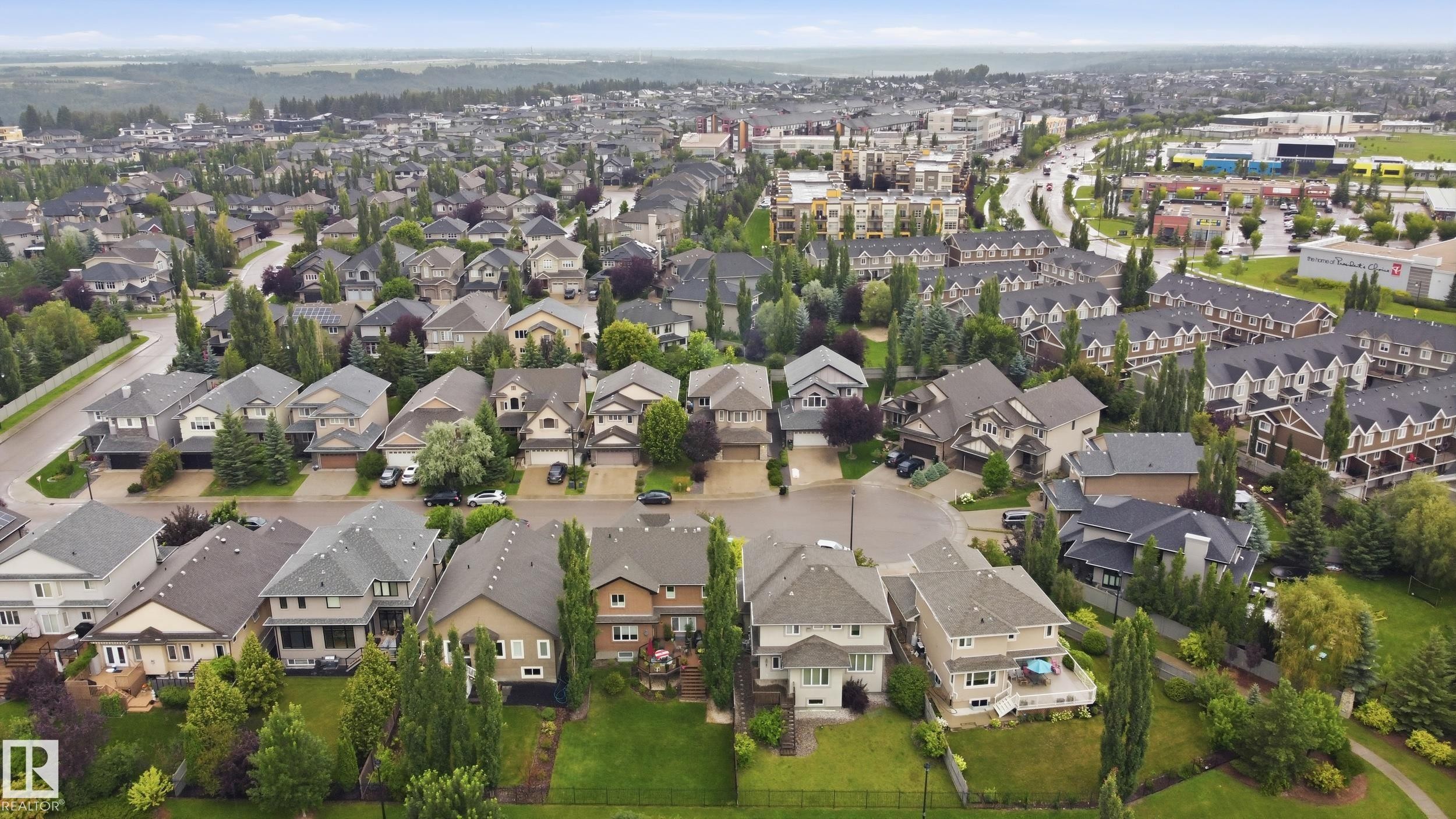 Aerial view showcasing an established residential community featuring single-family homes with varied architectural styles, mature landscaping throughout the neighborhood, and expansive green spaces - 2416 Warry Place Sw, Edmonton, AB - Outdoor With View