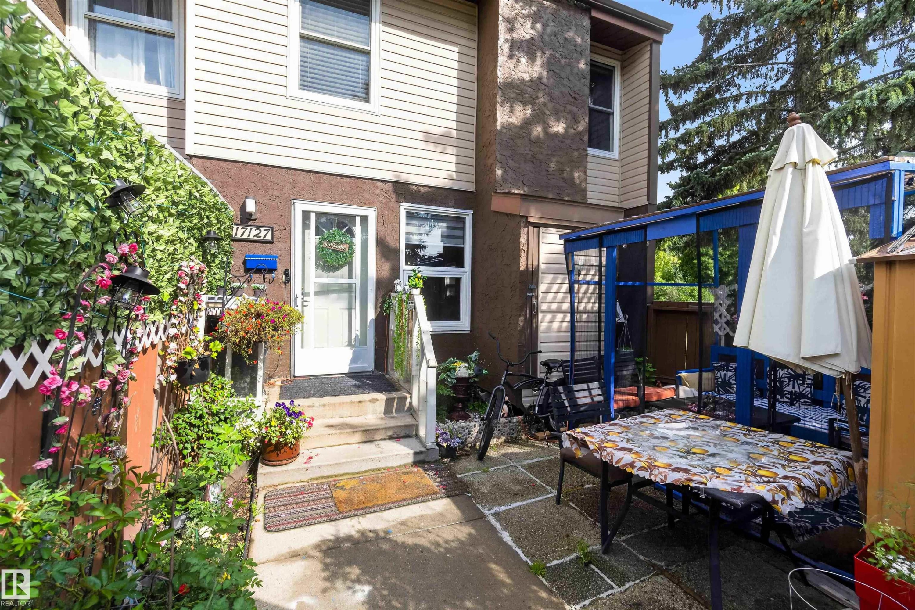 Entryway featuring an exterior door, adjacent windows, and a multi-level concrete staircase - 17127 109 Street Nw, Edmonton, AB - Outdoor