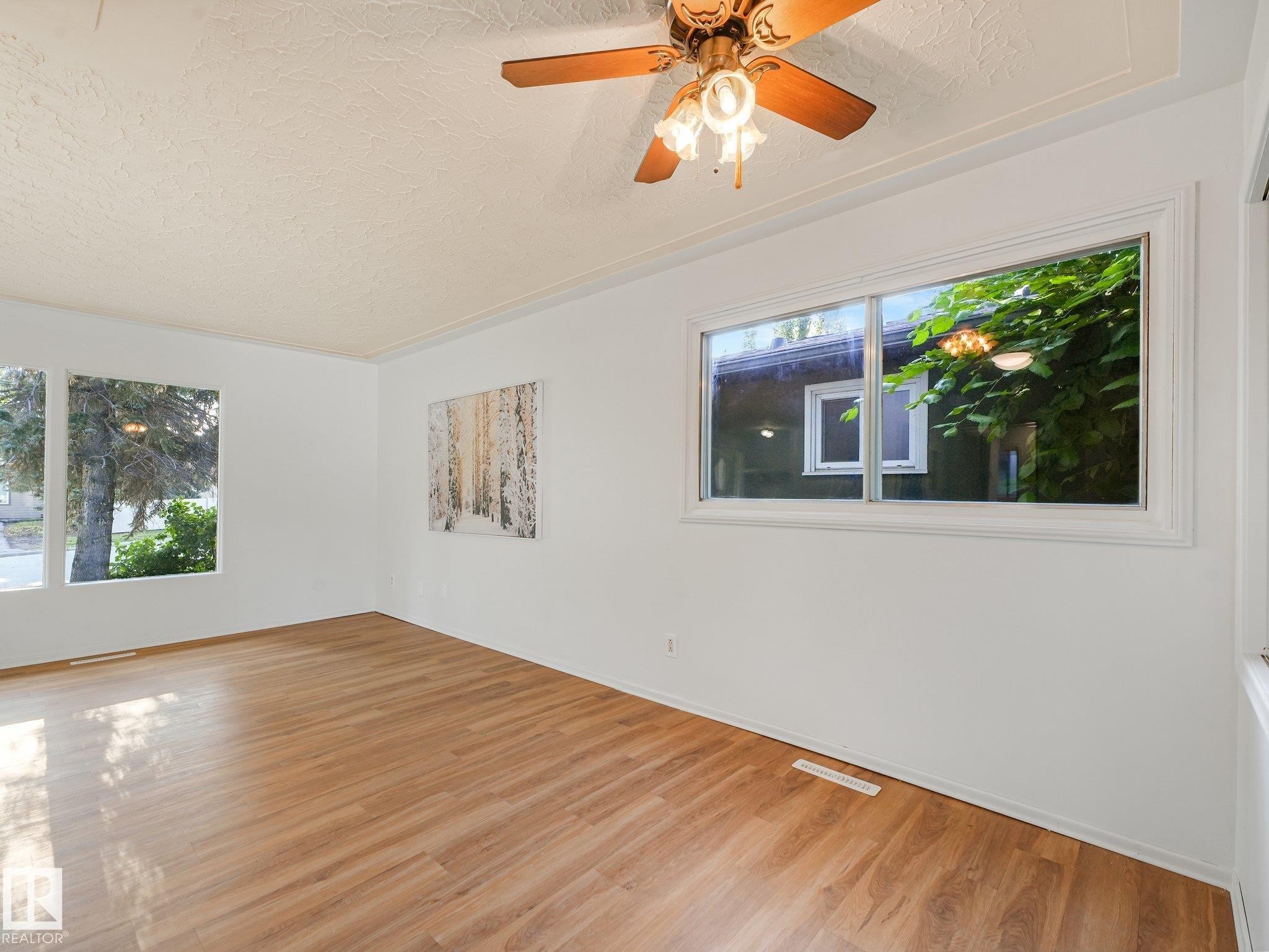 Wood-finish flooring, white walls, and a textured ceiling - 6112 105A Street Nw, Edmonton, AB - Indoor