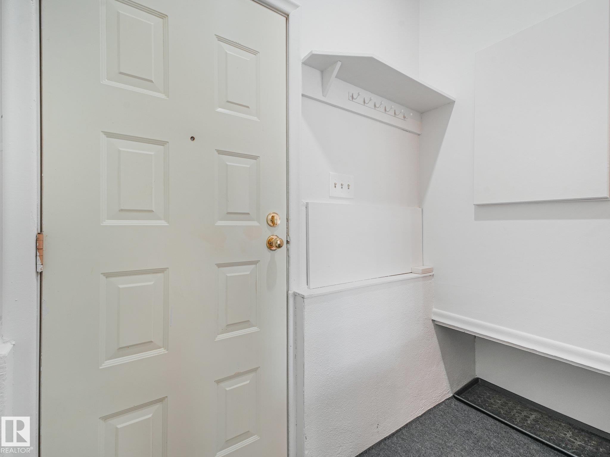 Utility room featuring white cabinetry with open shelving, white refrigerator with freezer compartment, and dark-finish flooring - 6112 105A Street Nw, Edmonton, AB - Indoor