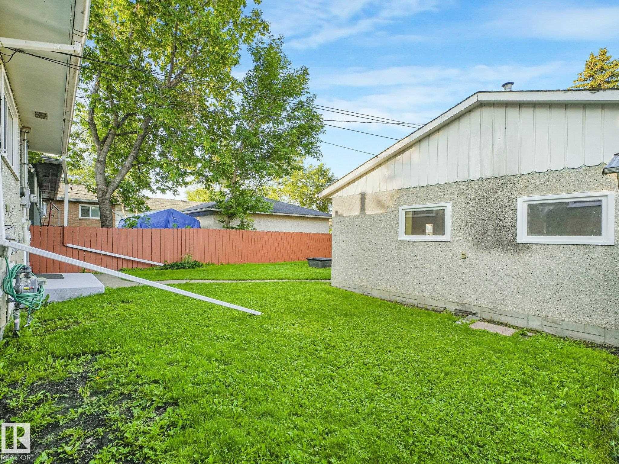 Expansive green space featuring a privacy fence and mature trees - 6112 105A Street Nw, Edmonton, AB - Outdoor