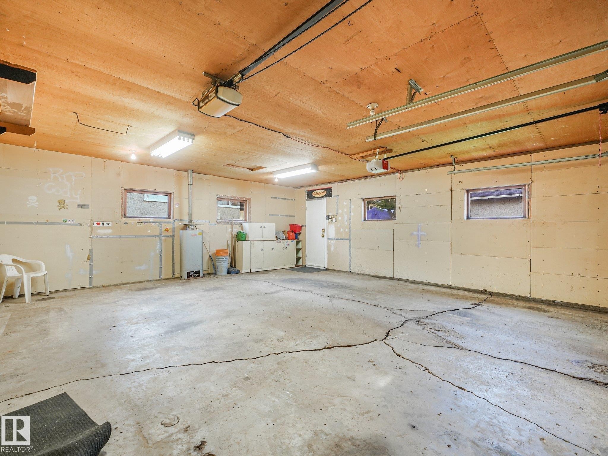 Garage with exposed wood ceiling, concrete flooring, and multiple windows - 6112 105A Street Nw, Edmonton, AB - Indoor Photo Showing Garage