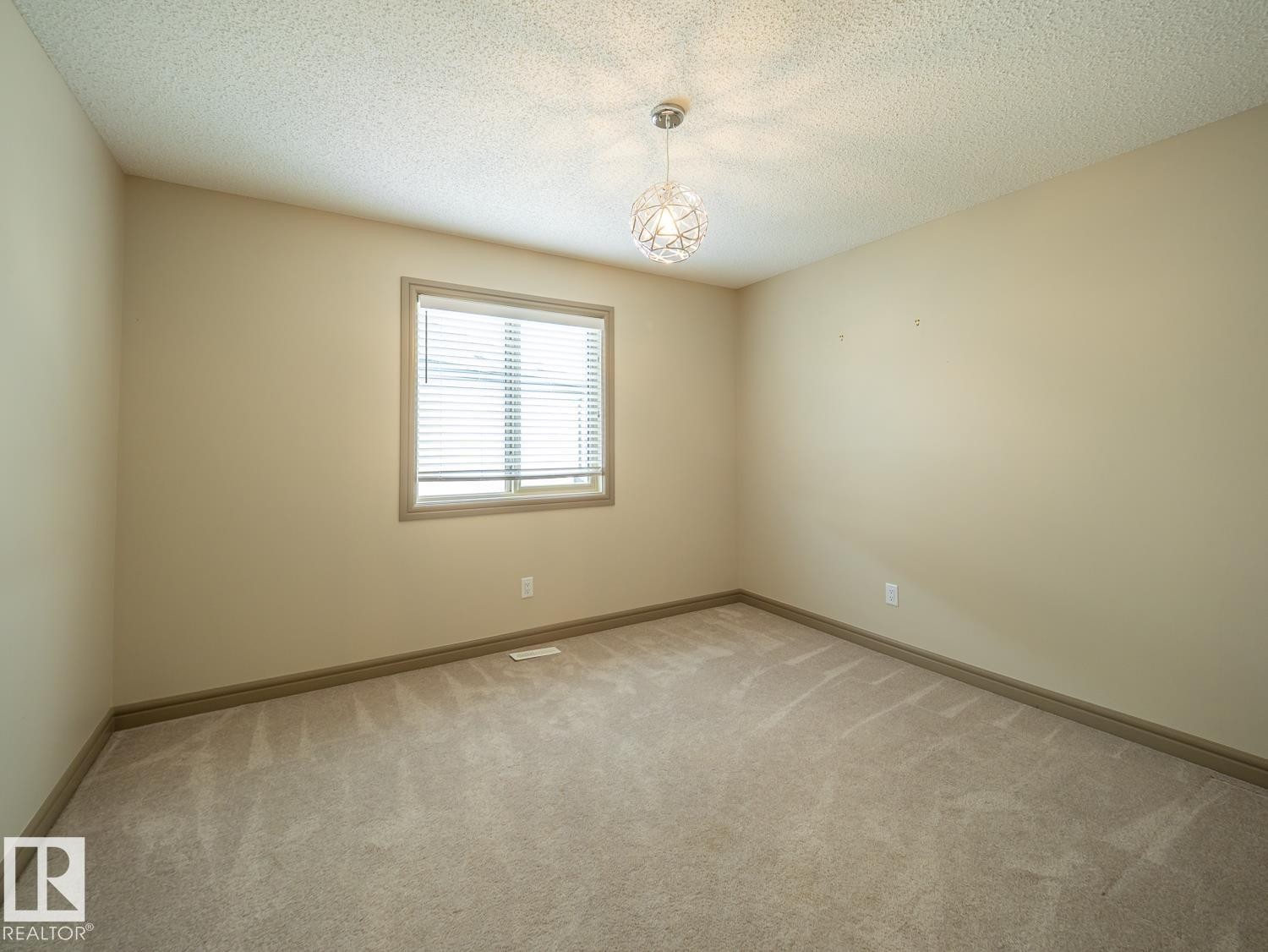 Neutral tone walls, ceiling-mounted light fixture, light-colored carpeting, and window with blinds - 97 Astoria Point(E), Devon, AB - Indoor Photo Showing Other Room