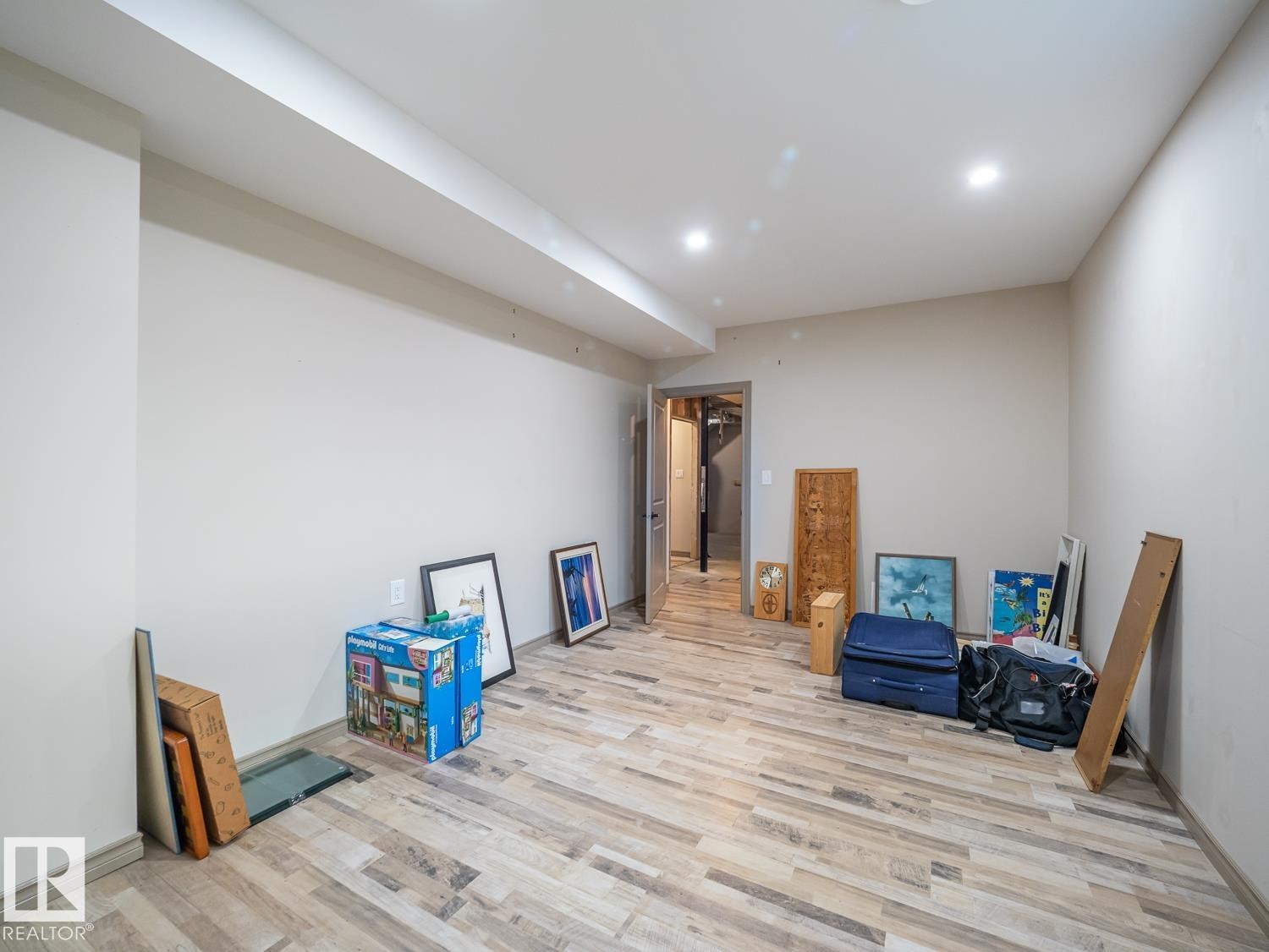 Recessed lighting illuminating the expansive room with wood-finish flooring - 97 Astoria Point(E), Devon, AB - Indoor