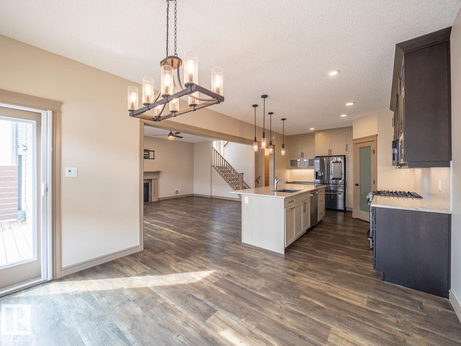 Expansive kitchen featuring a center island, pendant lighting, stainless steel appliances, and wood-finish flooring throughout - 97 Astoria Point(E), Devon, AB - Indoor Photo Showing Kitchen With Upgraded Kitchen