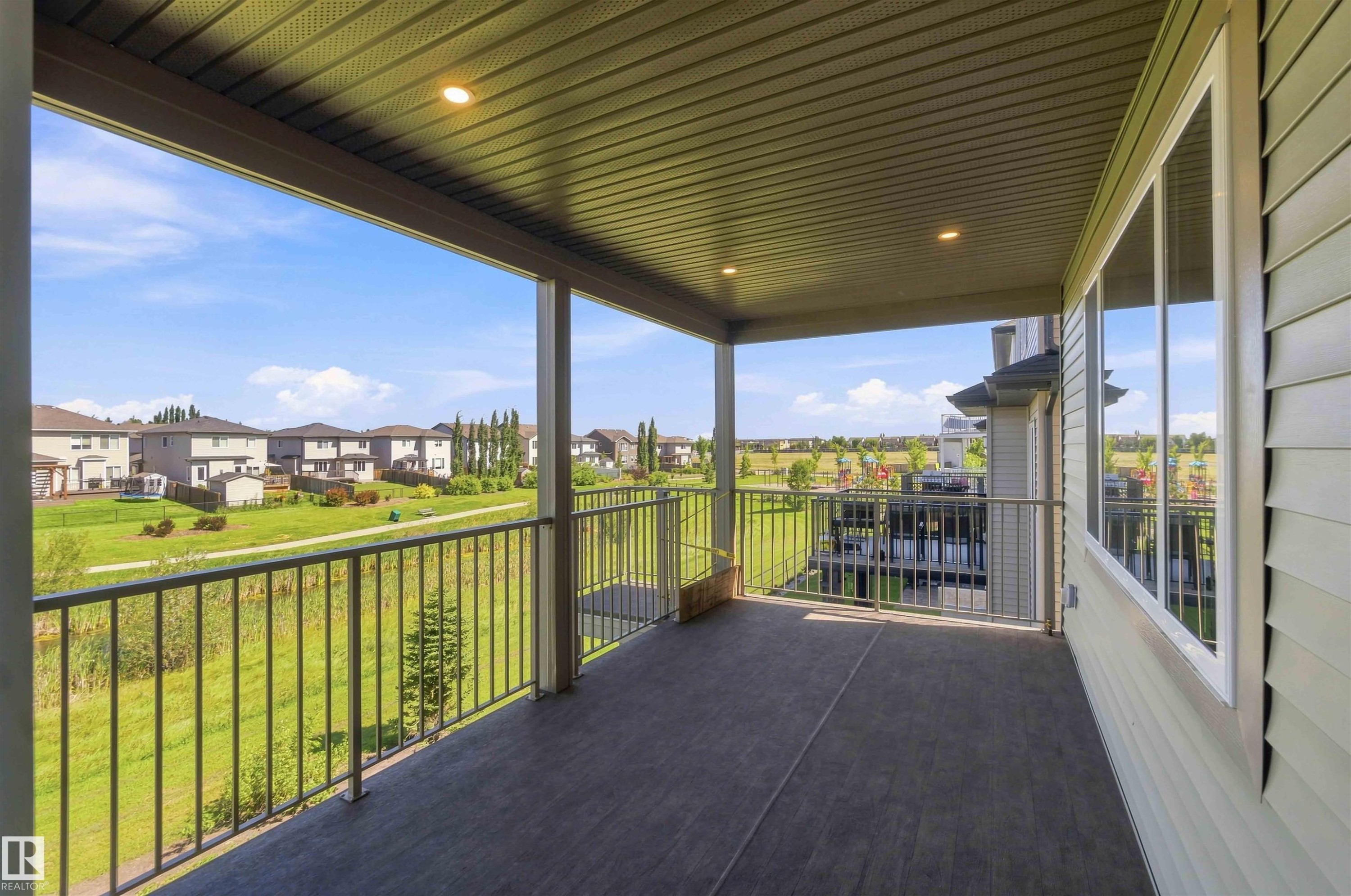 Covered outdoor balcony featuring recessed lighting, durable decking, and metal railings - 28 Harley Way, Spruce Grove, AB - Outdoor With Deck Patio Veranda With Exterior