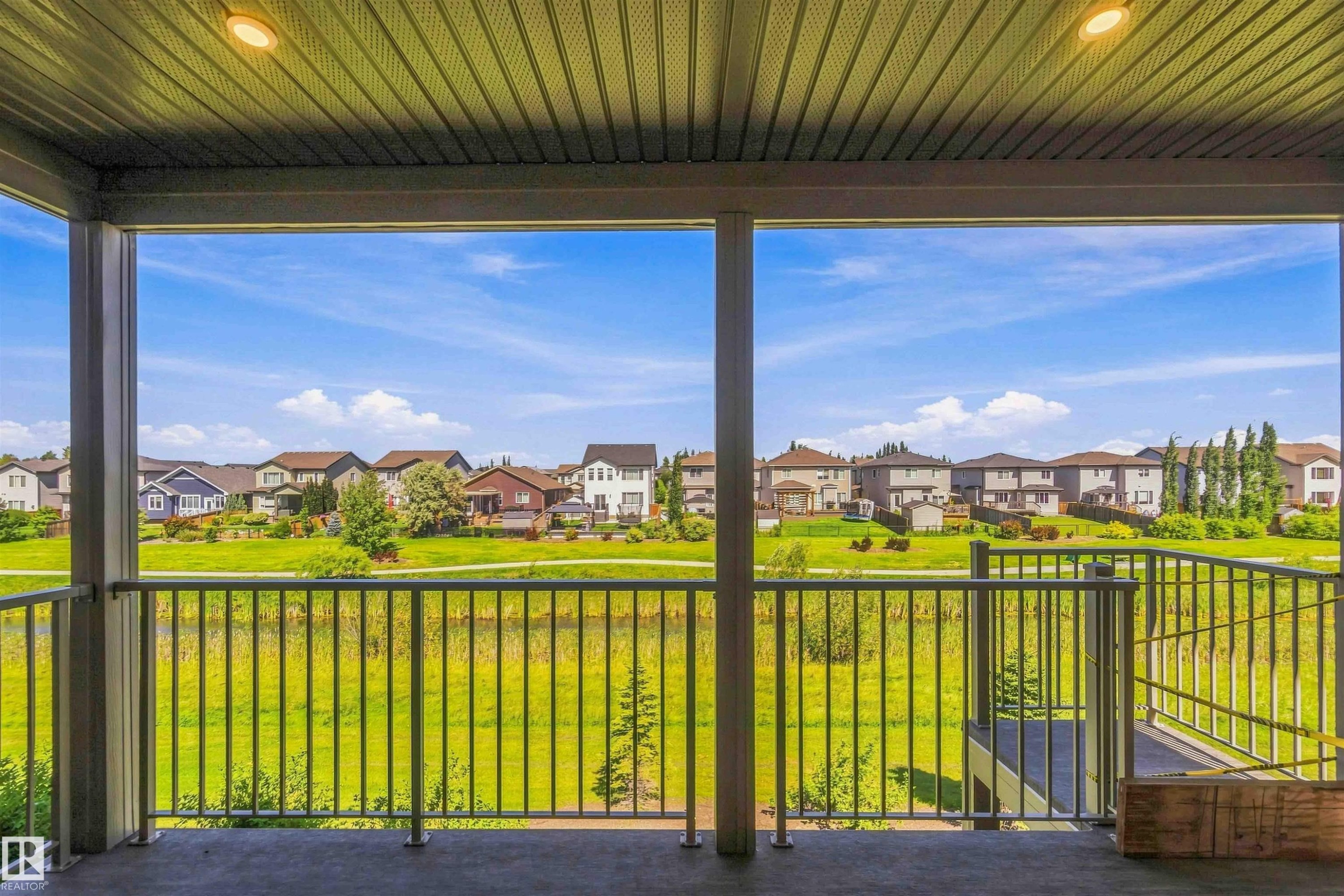Covered outdoor living space featuring a smooth concrete floor and metal railing - 28 Harley Way, Spruce Grove, AB - Outdoor With Deck Patio Veranda