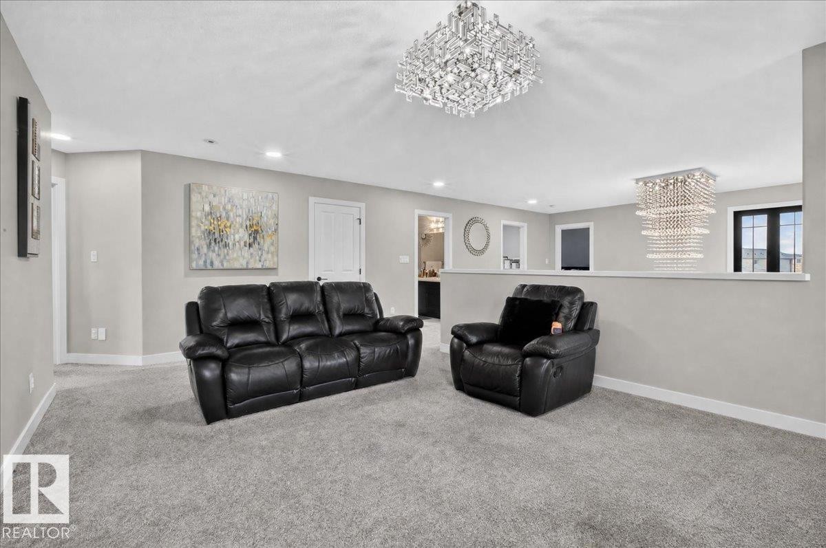 Recessed lighting, two crystal chandeliers, light gray carpeting, light gray walls, and white trim - 6813 Knox Loop Sw, Edmonton, AB - Indoor