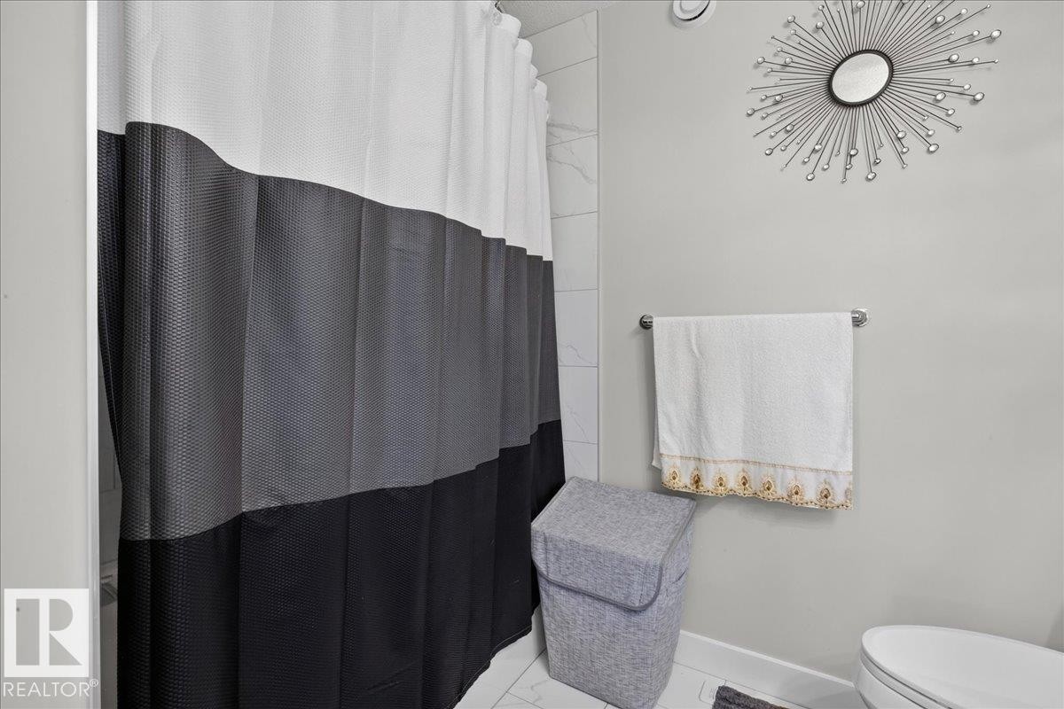 White wall tile shower surround, chrome towel bar - 6813 Knox Loop Sw, Edmonton, AB - Indoor Photo Showing Bathroom