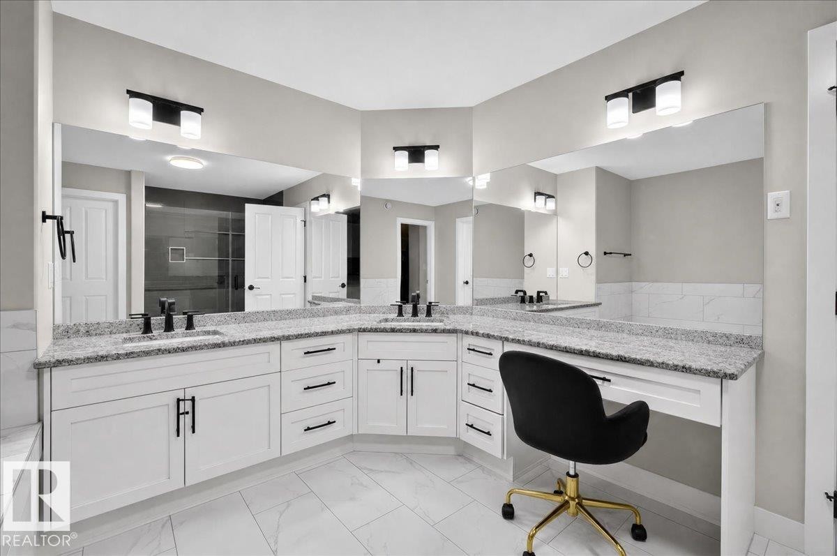 Corner vanity with dual sinks, granite countertops, white cabinetry, and matte black fixtures - 6813 Knox Loop Sw, Edmonton, AB - Indoor Photo Showing Bathroom