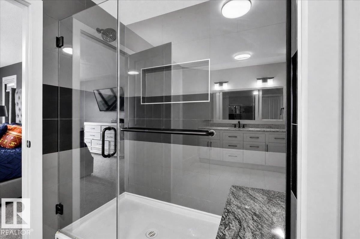 Glass-enclosed shower with a rainfall showerhead, tiled walls, and a built-in shelf - 6813 Knox Loop Sw, Edmonton, AB - Indoor Photo Showing Bathroom