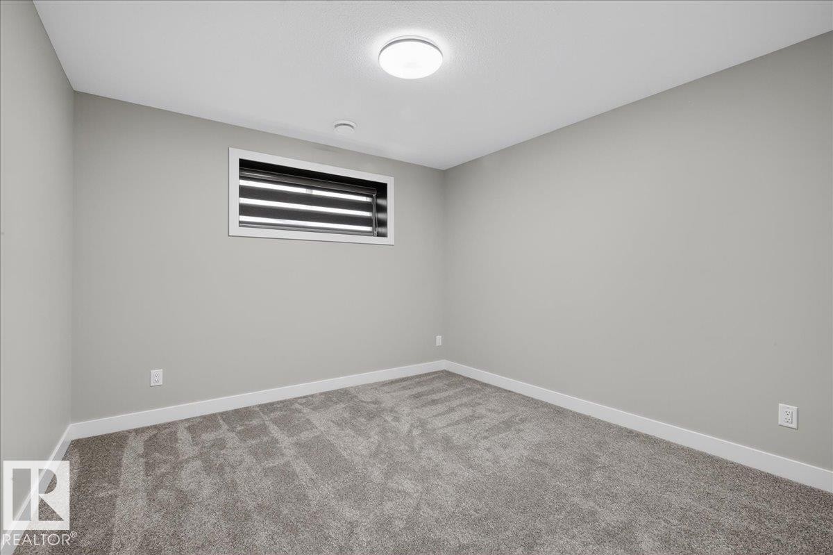 Neutral-toned walls with a single window, carpeted flooring, and a flush-mount ceiling light - 6813 Knox Loop Sw, Edmonton, AB - Indoor Photo Showing Other Room