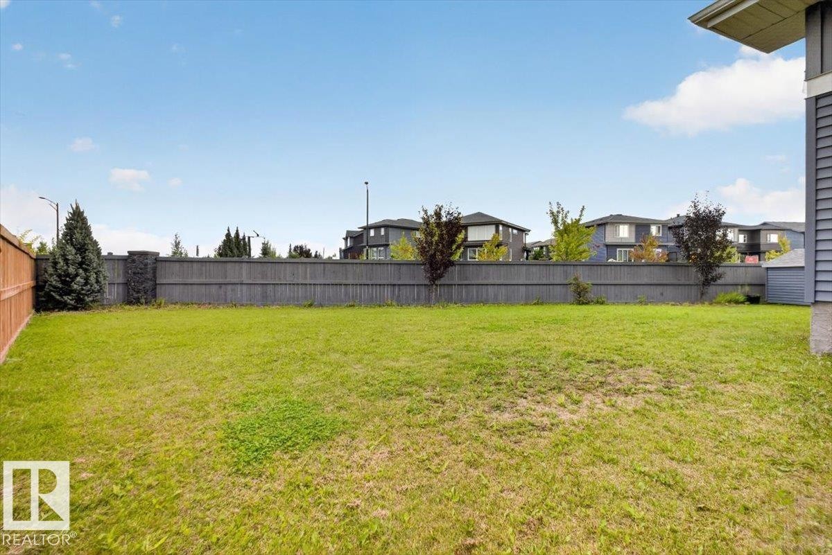 Expansive lawn with mature landscaping and established perimeter fencing, offering substantial outdoor space - 6813 Knox Loop Sw, Edmonton, AB - Outdoor With Backyard