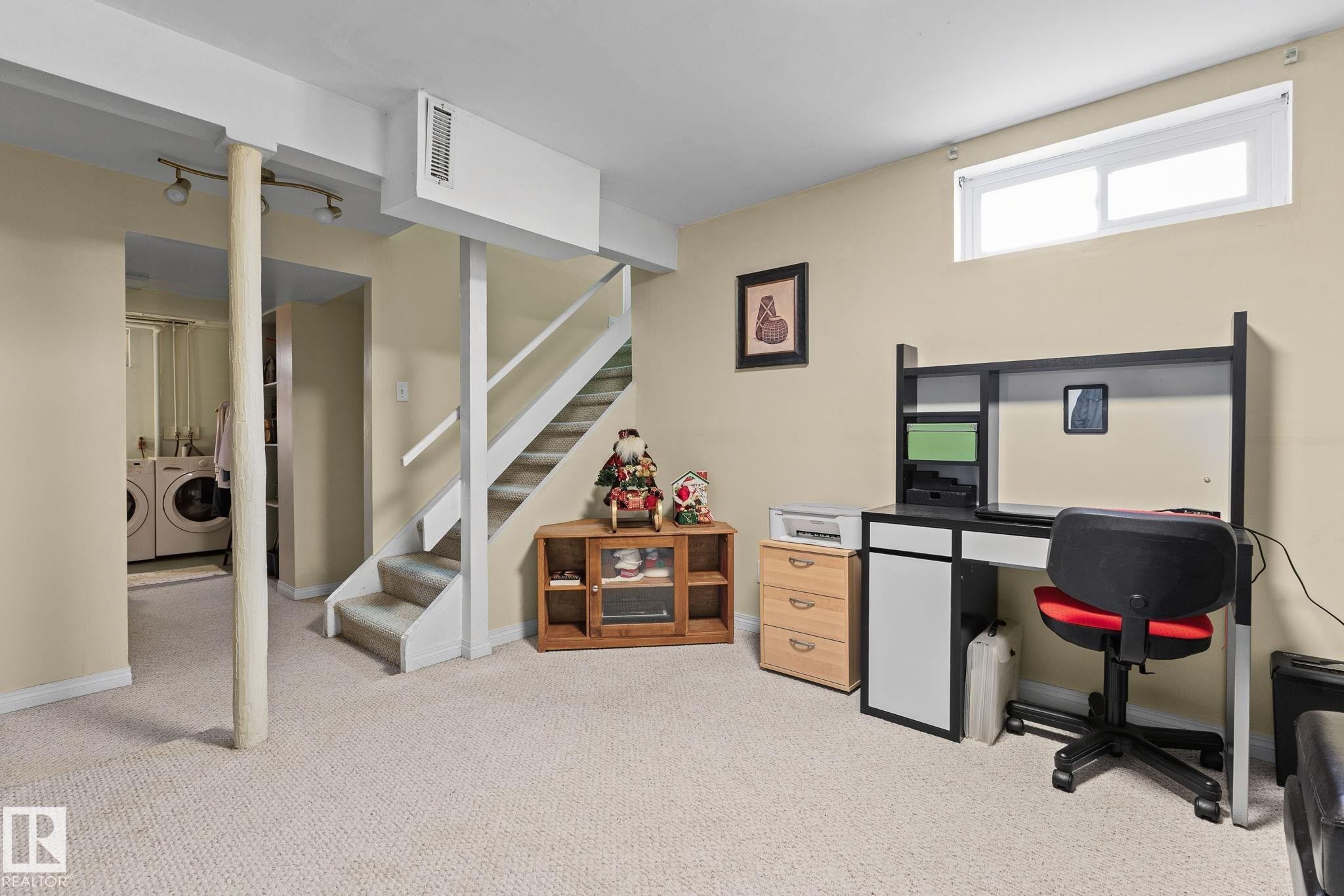 Carpeted flooring throughout, recessed window, and a staircase with white railings - 17132 103 Street Nw, Edmonton, AB