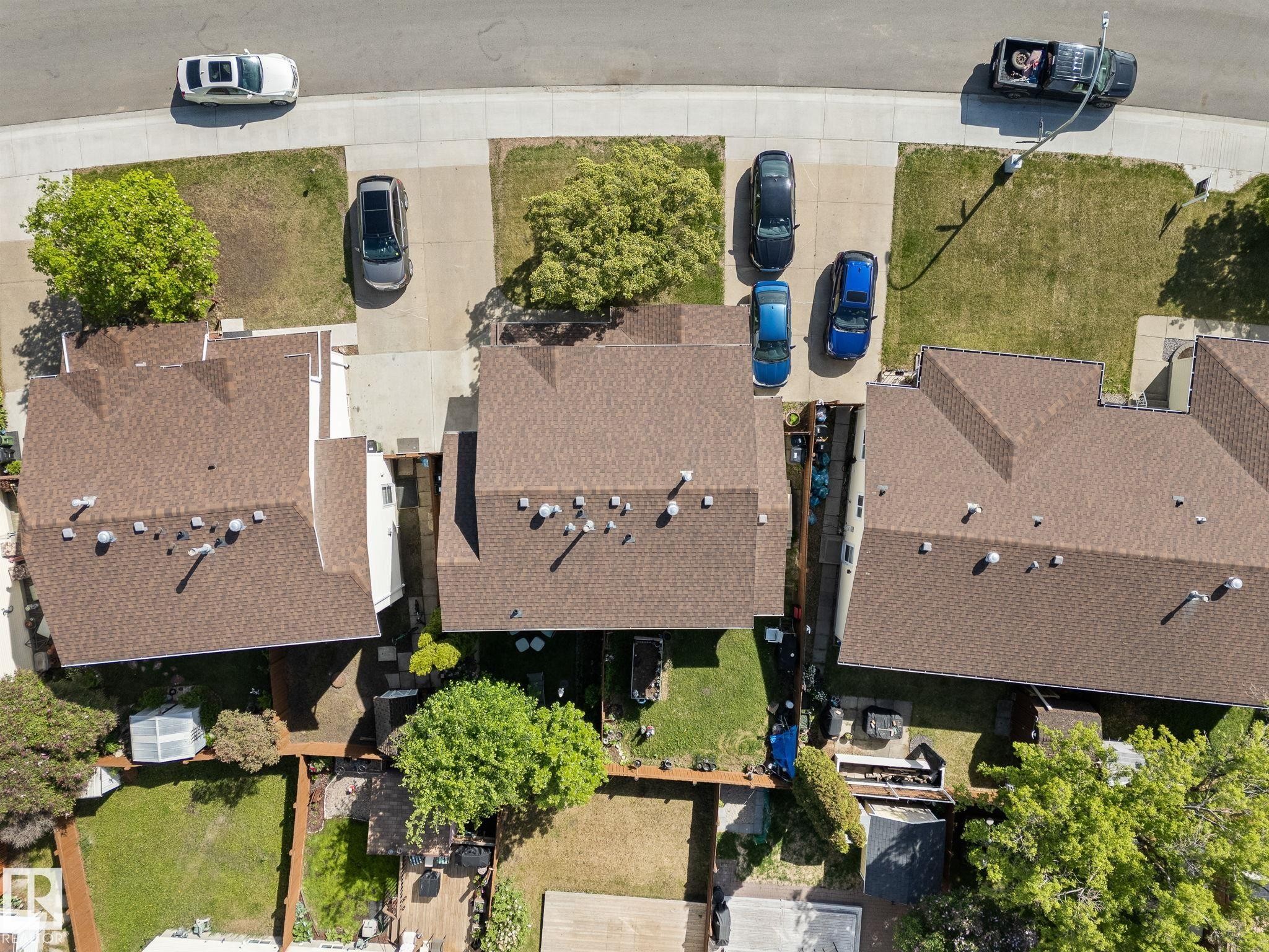 Property featuring a brown shingle roof, paved driveways, and green lawn areas - 17132 103 Street Nw, Edmonton, AB