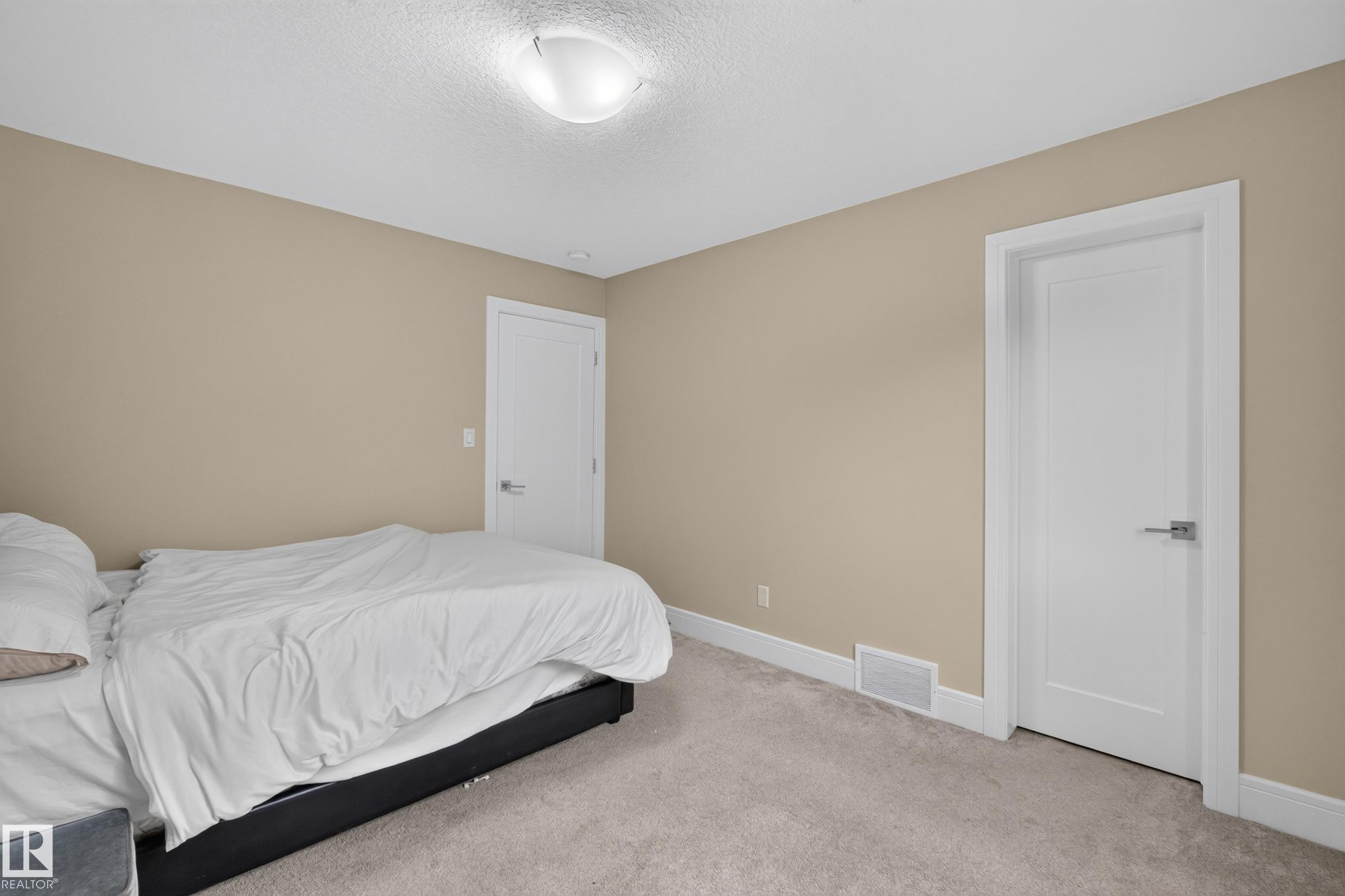 Neutral wall paint, white trim, two panel doors with satin nickel hardware, and a semi-flush mount ceiling light - 7014 Chivers Loop Sw, Edmonton, AB