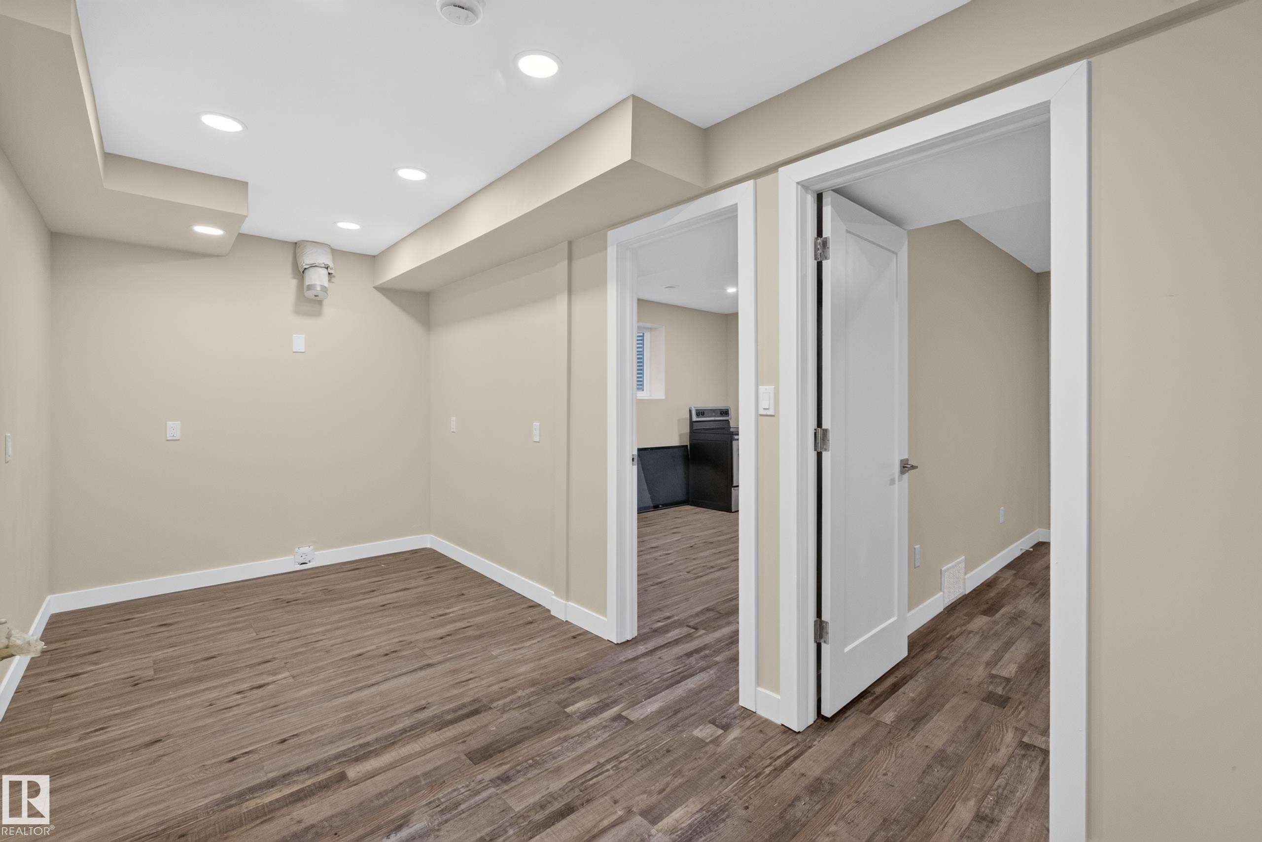 Recessed lighting, wood-finish flooring, neutral wall tones, white trim, and white paneled doors - 7014 Chivers Loop Sw, Edmonton, AB