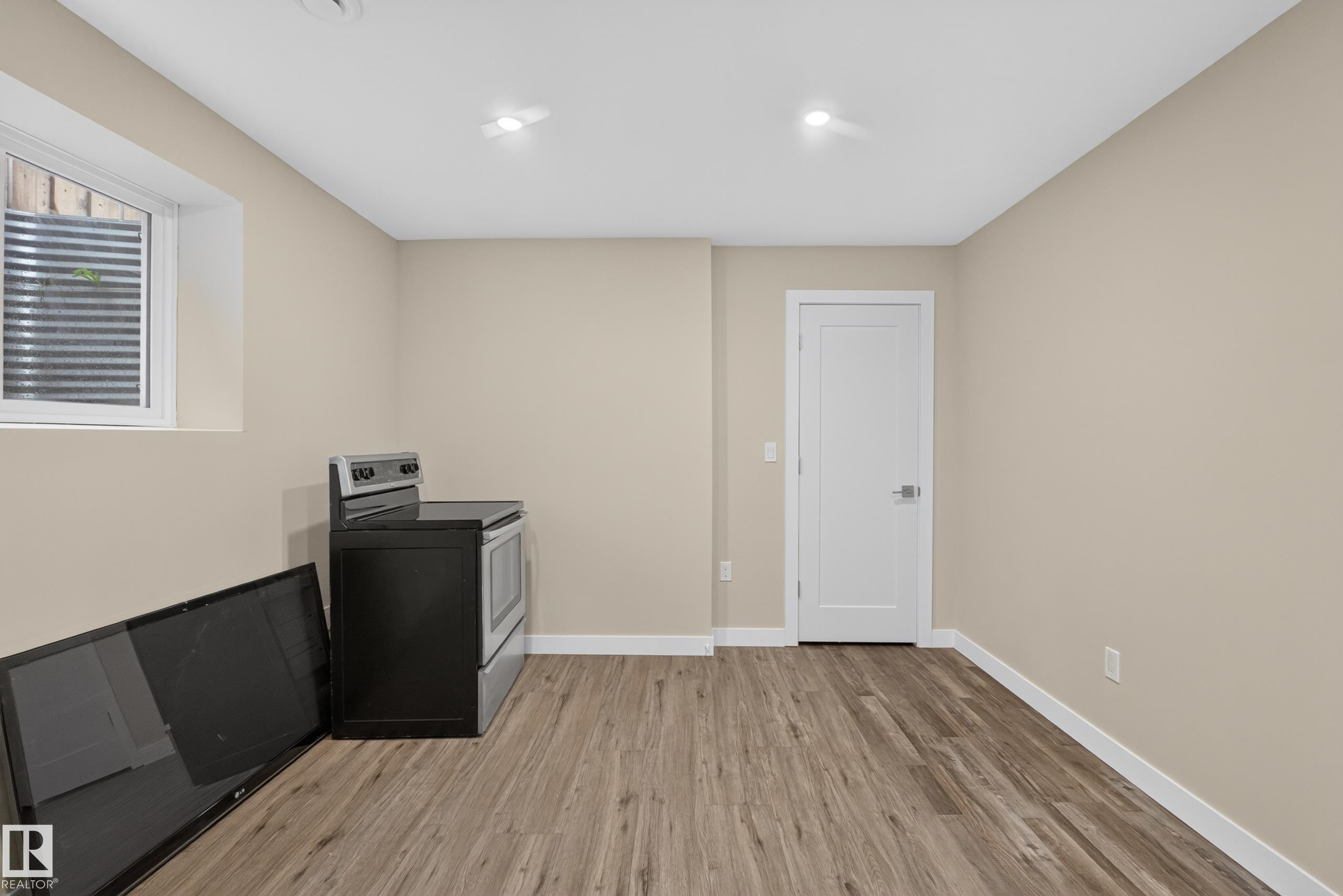 Recessed lighting illuminates the neutral wall tones and wood-finish flooring - 7014 Chivers Loop Sw, Edmonton, AB