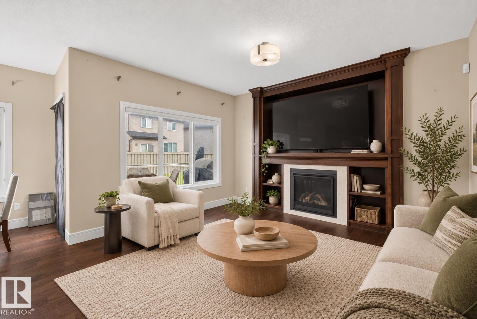 Built-in entertainment center with integrated shelving, fireplace, and mounted lighting fixture - 7014 Chivers Loop Sw, Edmonton, AB