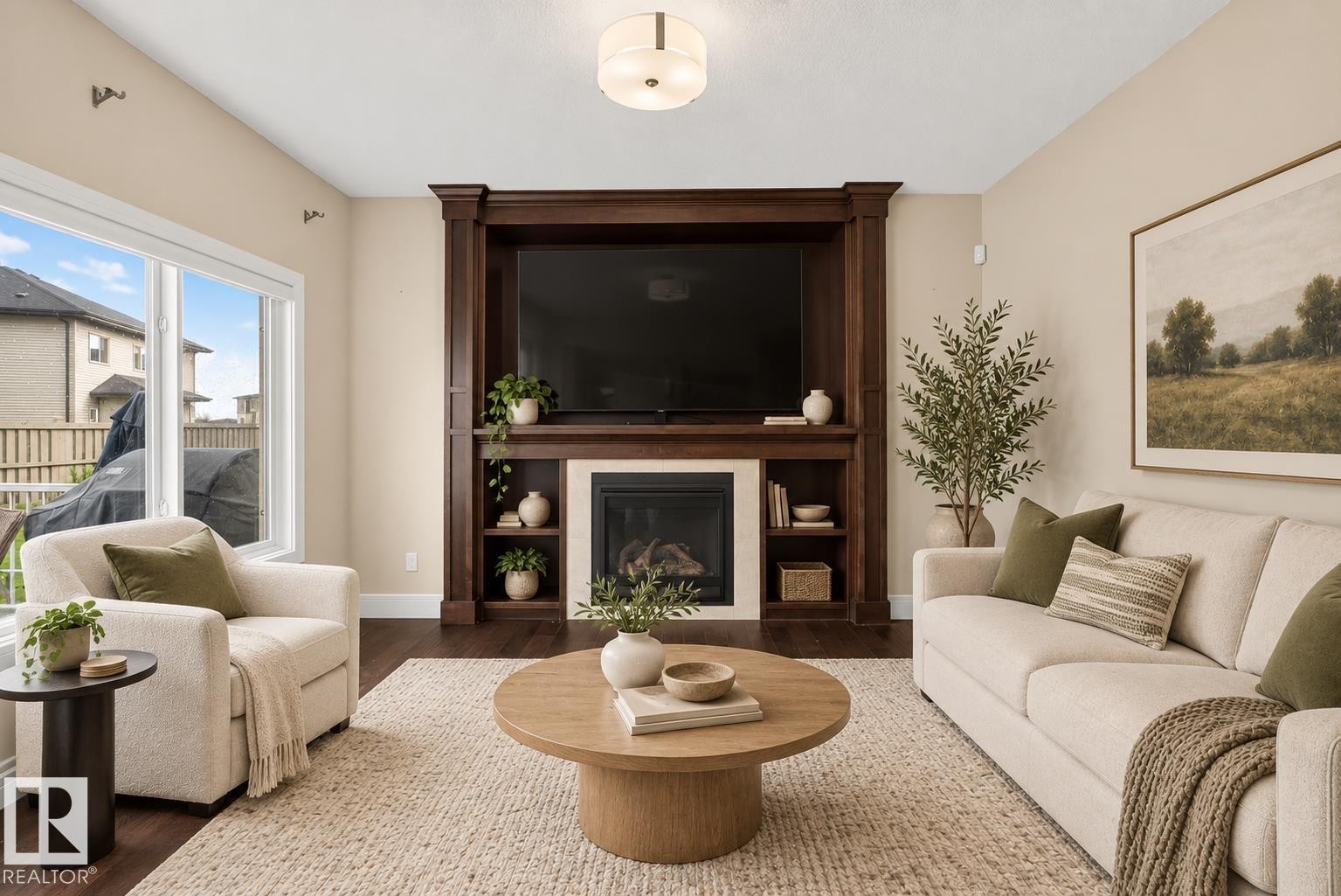 Built-in media center with integrated fireplace, large window with white trim, wood-finish flooring, and recessed ceiling lighting - 7014 Chivers Loop Sw, Edmonton, AB