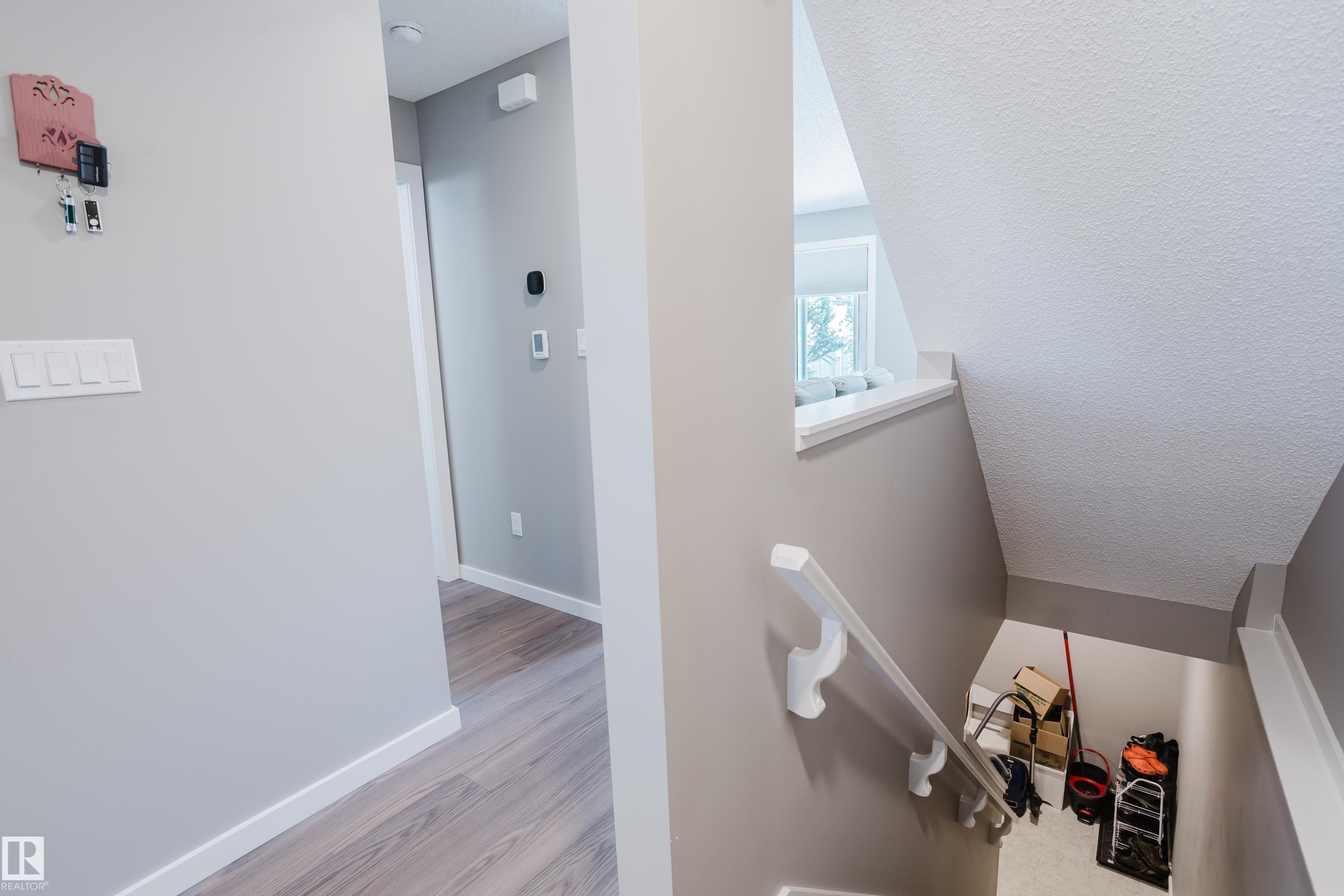 Hallway with wood-finish flooring, light grey walls, and white trim - #28 2215 24 St Nw, Edmonton, AB - Indoor Photo Showing Other Room