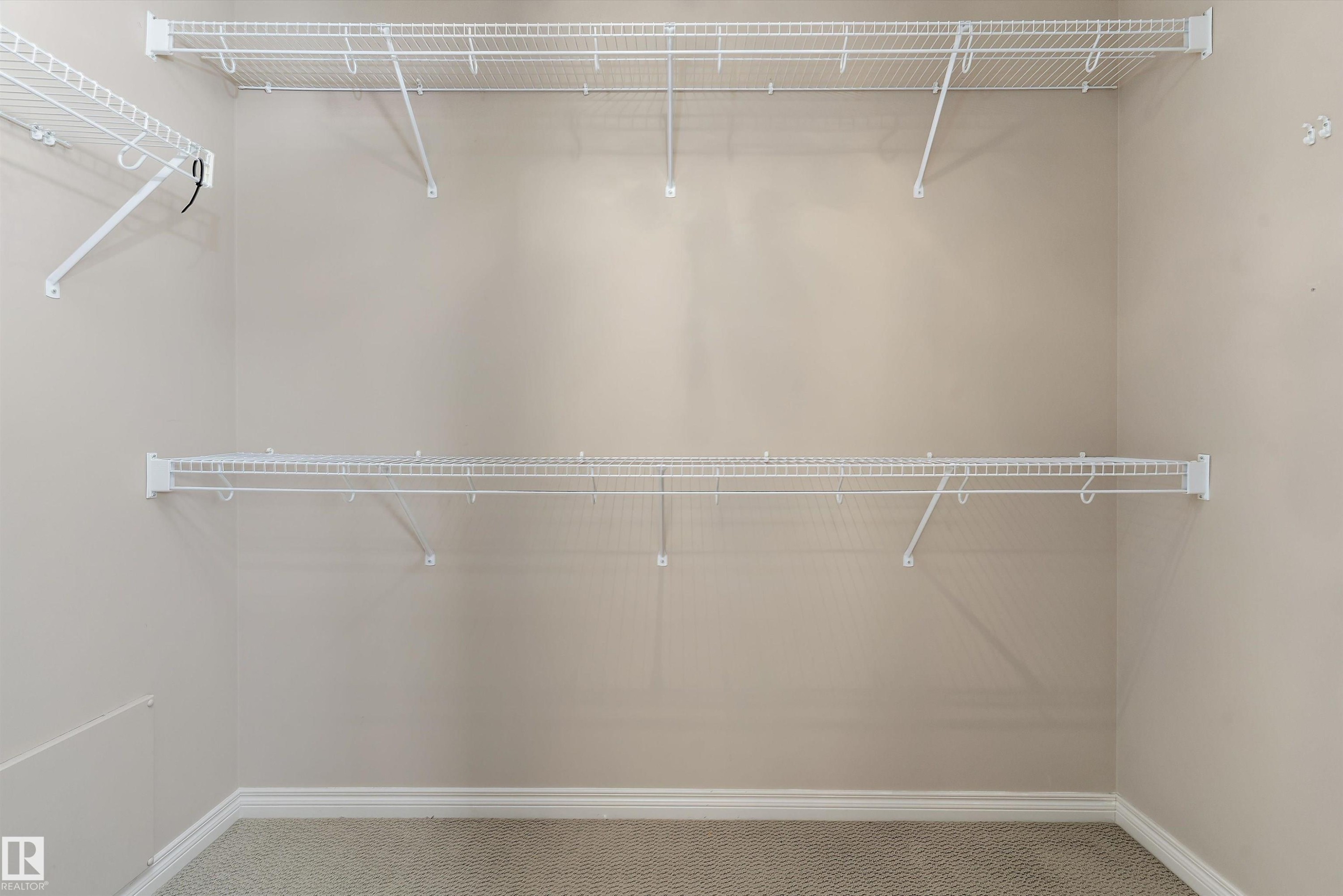 White wire shelving system, light-colored wall paint, and textured carpeting - 20845 92A Avenue Nw, Edmonton, AB - Indoor With Storage