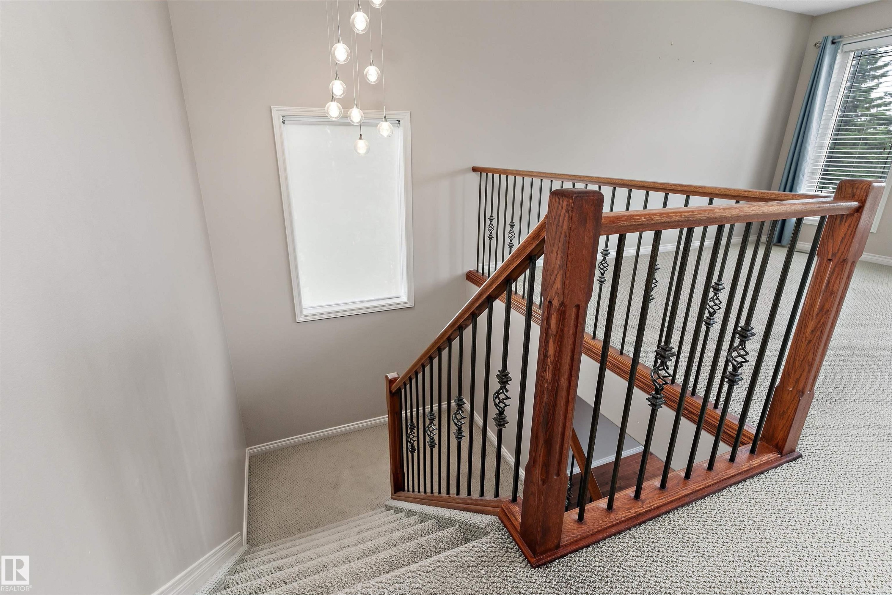 Staircase with wood-finish handrails, decorative wrought iron balusters, and carpeted treads - 20845 92A Avenue Nw, Edmonton, AB - Indoor Photo Showing Other Room
