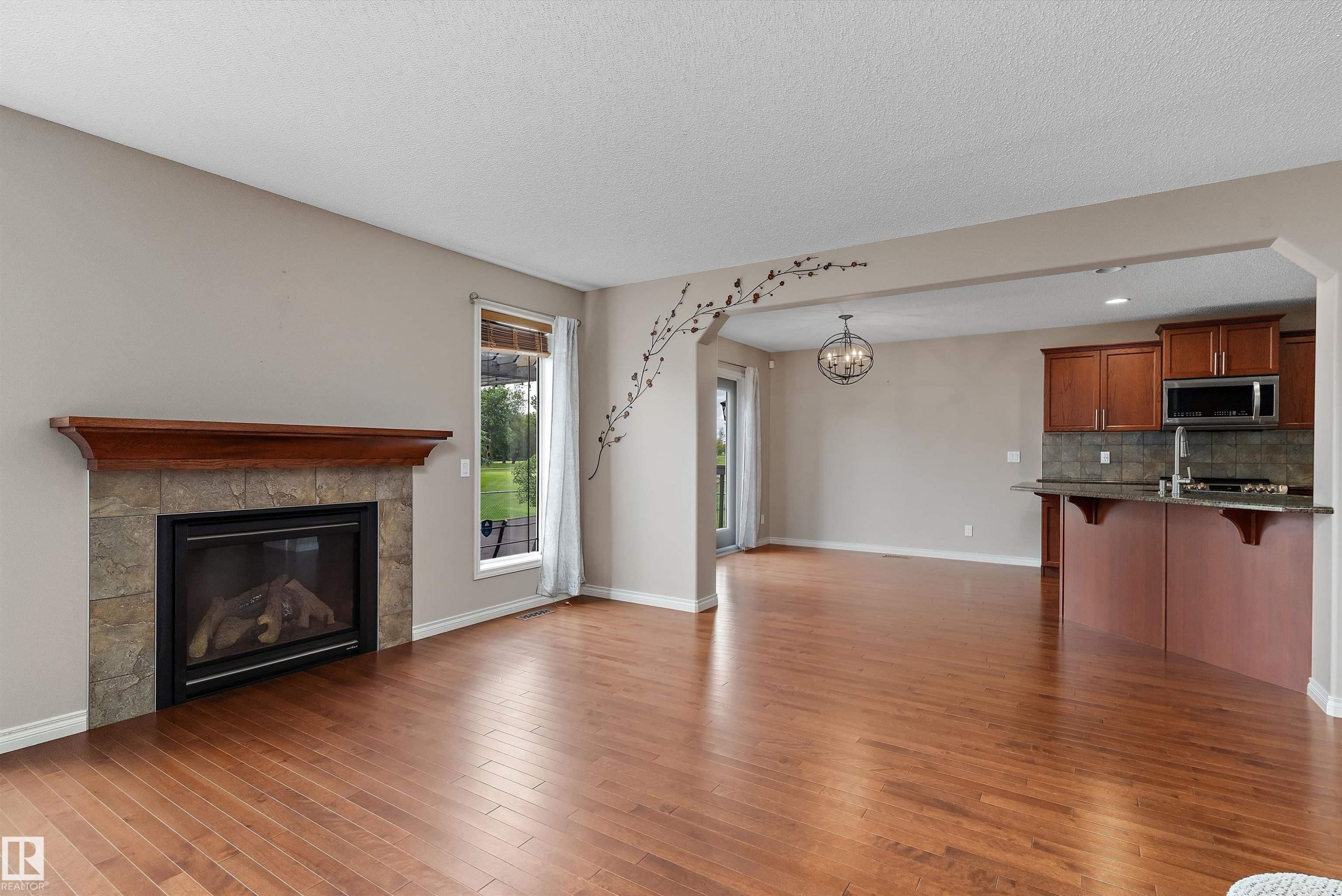 Hardwood-style flooring throughout - 20845 92A Avenue Nw, Edmonton, AB - Indoor Photo Showing Other Room With Fireplace